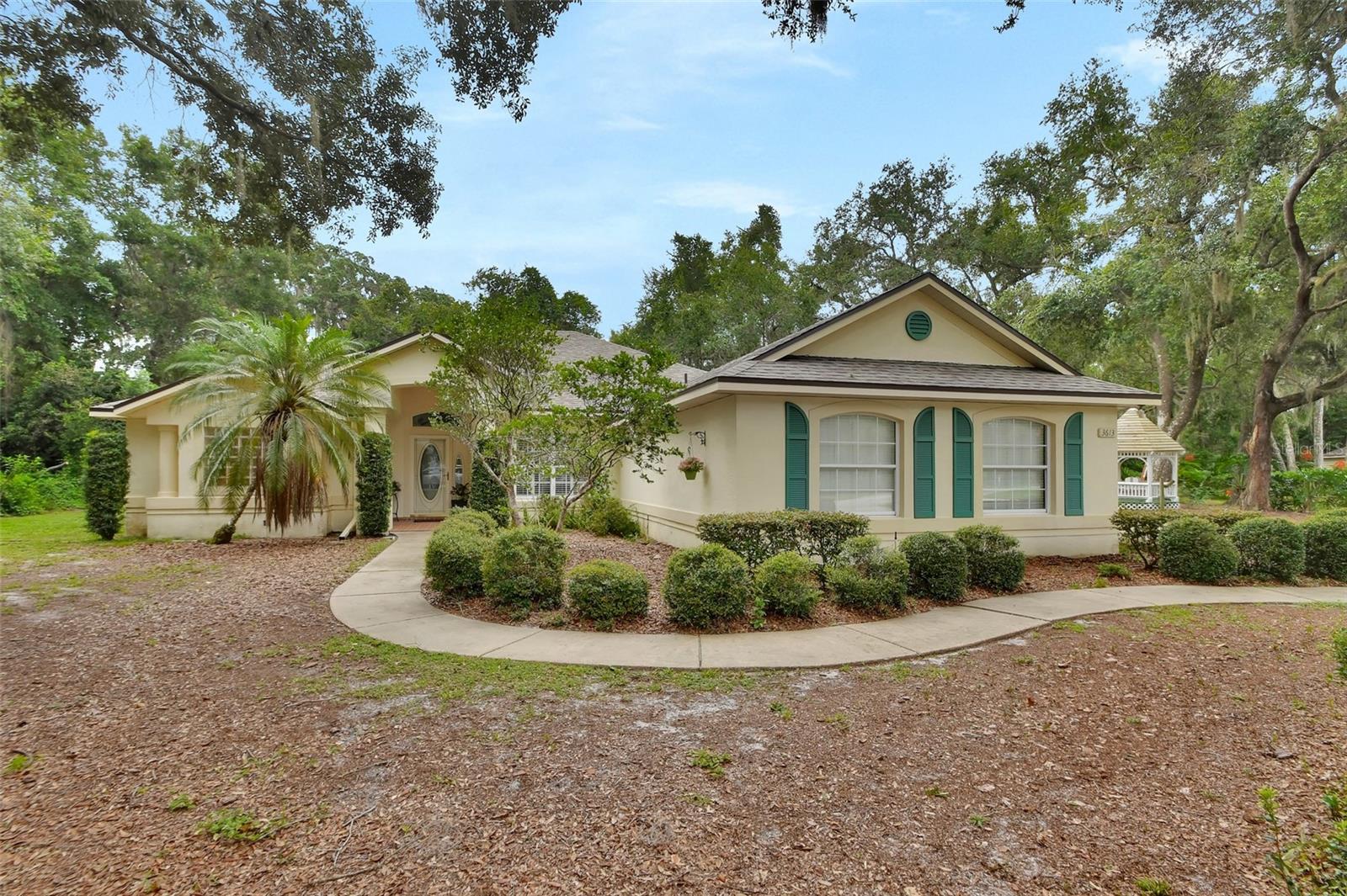 Gorgeous Home Nestled on 1/2 Acre in a Quiet, Peaceful, Gated Neighborhood Surrounded by Beautiful Homes, Access to Lake Mamie,
Spacious 3 Bedroom, 3 Bath Split Plan. Step into the Foyer to a Large Living Room With Beautiful Coffered Ceiling With Crown Molding. Several French Doors Lead to the Huge Air Conditioned Florida Room. There are Plantation Shutters Throughout and some Stained Glass Windows. There is a Walk In Pantry and an Inside Laundry Room. The Dinette Of the Kitchen Overlooks the Backyard and Paver patio. The Primary Bath Features Double Sinks, a Garden Tub and Separate Shower. The large Primary Bedroom has a Sitting Area, Two Closets and French Doors. The Second Bedroom Has a Murphy Bed. Enjoy Your Morning Coffee in the Adorable Gazebo. There is a 2.5 Car Garage For Extra Storage. Newer Roof 2021, A/C 2016. Located Just 15 Minutes From Shopping, Restaurants, Hospital, 30 Minutes to Daytona Beach, 60 Minutes to Orlando and Attractions. Call Today to See This Beautiful Home! All Information Believed Correct. Buyer and Buyer's Agent to Verify. The Home May Be Under Video/Audio Surveillance.