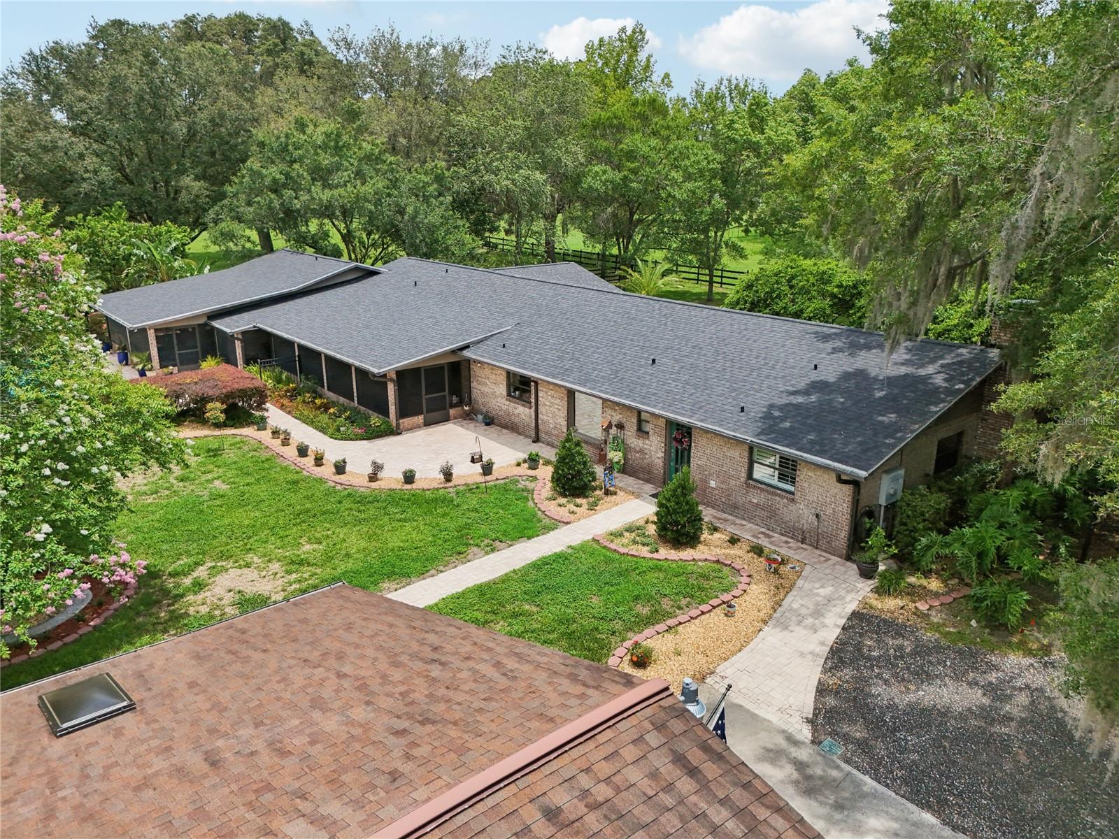 Elegant Country Estate with Equestrian Amenities Just Minutes from Downtown DeLand offered at $1,024,900 – A Rare Value for this Lifestyle Property.
Welcome to your private, custom-built retreat nestled on nearly 7 tranquil acres in DeLand’s highly sought-after Glenwood area. This expansive 4-bedroom, 3.5-bath residence with a large den (or optional 5th bedroom) offers 3,871 square feet of luxurious living space and is perfectly designed for entertaining, multigenerational living, and enjoying the Florida lifestyle at its finest.
Located just 10 minutes from award-winning Downtown DeLand—voted Best Mainstreet in America—this estate combines peaceful country living with quick access to boutiques, fine dining, a microbrewery, wine bars, and the St. Johns River boat ramp. Daytona Beach is just 25 minutes away, and Orlando’s attractions are within a 45-minute drive.
The property features three cross-fenced pastures, majestic 100-year-old oaks, palms, magnolias, and blooming crepe myrtles. The attached multi-vehicle garage and adjoining barn include a workshop, 3 horse stalls, tack room, upper loft for storage, and a large parking pad for your RV or boat.
Inside, the home boasts a thoughtful split floor plan with two spacious master suites—each with private en suite bathrooms. The larger primary suite includes a dedicated HVAC system, spa-inspired bathroom with an oversized walk-in shower and dual shower heads, a luxurious vanity with granite countertops and dual sinks, and a designer walk-in closet with custom storage.
The gourmet kitchen is a chef’s dream with a large L-shaped island, hidden storage compartments, double ovens, Dacor digital cooktop, spice pull-out, and floor-to-ceiling pantry cabinets with pull-out drawers. A nearby butler’s pantry doubles as a catering prep space with second fridge, second dishwasher, farmhouse sink, and laundry area.
Entertain in style in the formal dining room featuring a 144-bottle wine rack, charming brick built-ins, and upgraded Anderson sliding doors that open completely to the screened patio. The adjacent family room showcases a beautiful stone fireplace and plantation shutters. A wet bar near the breakfast nook adds another touch of refinement.
The outdoor living area offers a true resort-like experience with a saltwater pool, expansive deck, outdoor fireplace, and lanai—ideal for relaxing or entertaining. Recent updates include a new roof, AC units, upgraded garage insulation and electrical, water softener and filtration system, RainBird irrigation, remote entry gate, and Bose surround-sound system.
This one-of-a-kind property is a rare find in today’s market. Call today to schedule your private tour—and don’t miss the stunning video walkthrough of this incredible estate! Assumable VA loan available!