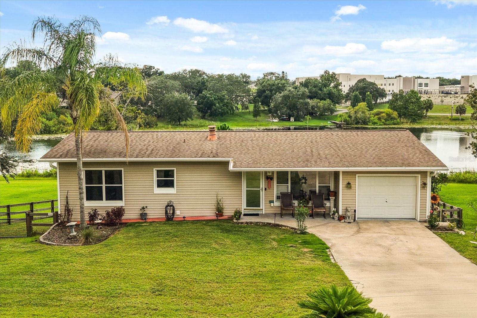 **This house comes with a REDUCED RATE through the seller's preferred lender. This is a lender-paid rate buydown that reduces the buyer's interest rate and monthly payment.** Discover this hidden gem in the heart of Clermont offering nearly 2,300 square feet of unique living space on almost half an acre with stunning water views. This single-family home is anything but ordinary, with a rare two-story layout designed into a gentle slope. The main level sits at street level, while the lower level opens directly to the expansive backyard and water beyond, creating a layout that feels both spacious and private. As you walk in, you're immediately welcomed by an open-concept living, dining, and kitchen area filled with natural light. The dining room features sliding glass doors that lead to a dream-worthy deck—perfect for morning coffee or sunset dinners. Just off to the side, a covered porch offers a shaded, peaceful spot to relax while taking in serene views of your blank canvas backyard and the tranquil water below. The kitchen is designed to impress with warm-toned cabinets topped with crown molding, stone countertops, stainless steel appliances, and a central island with breakfast bar seating. A stone-lined fireplace adds warmth and character, positioned between the hall leading to the primary suite and the stairs down to the lower level. The spacious primary bedroom offers a walk-in closet, an ensuite bathroom with a walk-in shower, and windows facing the backyard and water—giving you front-row seats to breathtaking sunset views each evening. Downstairs, you’ll find two additional bedrooms with built-in closets, a large secondary living and dining area, and a corner wet bar with open counter space and room for bar seating—ideal for entertaining or creating a private guest or in-law suite. There’s also a second full bathroom with a tub/shower combo conveniently located off the dining area. Sliding doors lead from this level to a covered rear patio that overlooks the fenced-in yard, mature trees, and the water beyond. Just past the fence line, a wooden deck currently used for fishing awaits—perfect for enjoying Florida’s outdoor lifestyle to the fullest. 660 Shady Nook Drive is a one-of-a-kind home offering flexibility, comfort, and stunning views in one of Clermont’s most peaceful settings. Come experience this rare layout, endless potential, and tranquil surroundings for yourself—your dream home may be waiting right here.