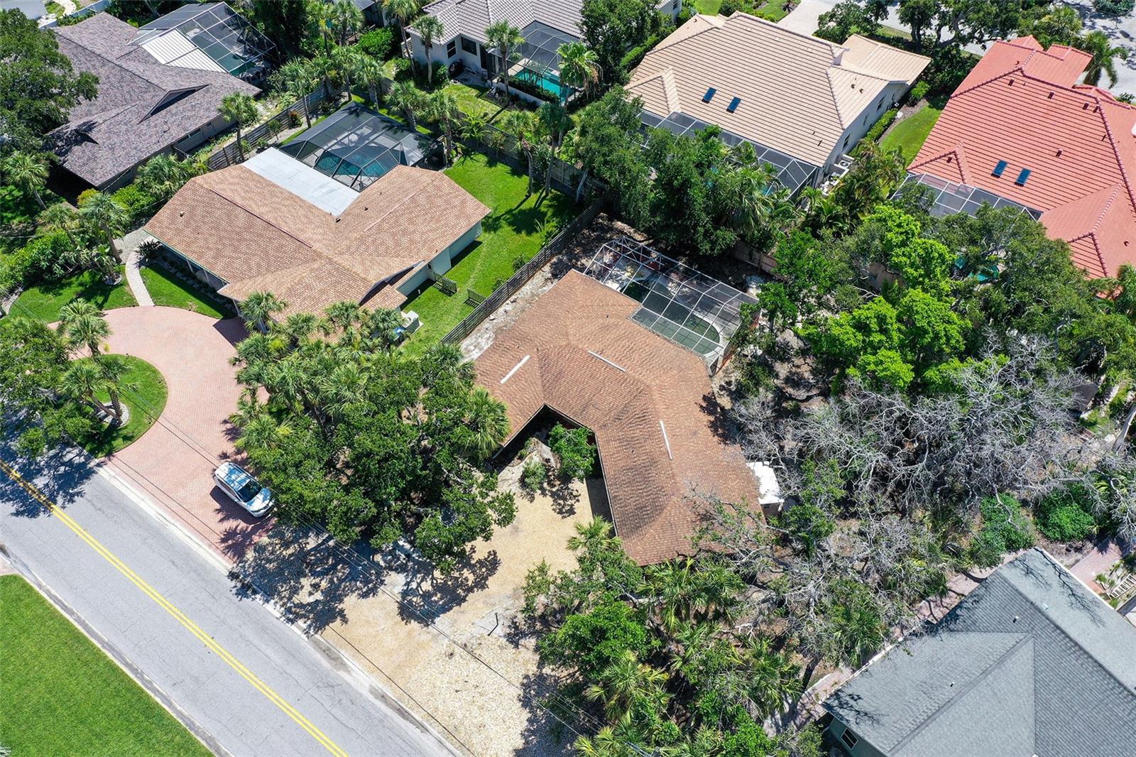 Nestled on picturesque Shadow Lawn Drive, this 12,800-square-foot lot offers an exceptional canvas for your custom home. Framed by mature live oaks on the front left and back right corners, the property blends natural beauty with an enviable location.
Enjoy the best of Siesta Key living—just an 8-minute stroll to the powdery sands of world-famous Siesta Beach and just over a mile to the dining and shopping of Siesta Village. Despite its proximity to these sought-after amenities, the property feels peaceful and secluded, tucked away on a quiet street removed from the island’s main thoroughfares.
With nearly 100 feet of street frontage and a depth of 120 feet, the lot offers a generous and flexible building footprint. Whether you envision a sleek, modern coastal retreat or a charming, classic island cottage, this is a rare opportunity to create your ideal Siesta Key home in one of its most desirable neighborhoods.