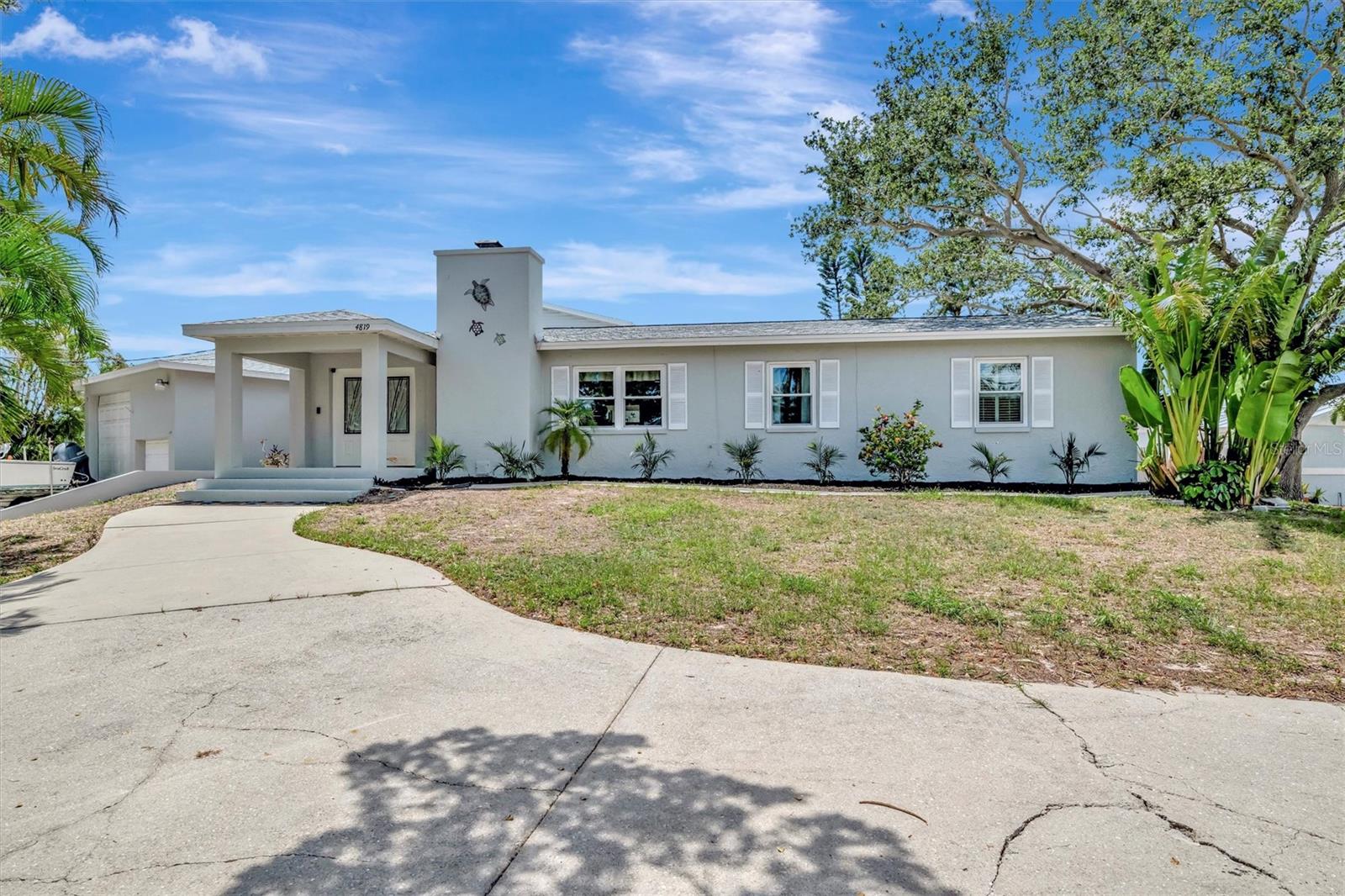 This spacious and bright residence, situated on a generous corner lot, epitomizes waterfront living. The open floor plan features four bedrooms and three-and-a-half bathrooms, including two ensuite bedrooms. The second-floor primary suite offers dual walk-in closets, jetted tub, walk-in shower, and views of the bay and canal. Designed for both comfort and entertainment, the home boasts a heated pool and an expansive screened lanai, ideal for relaxation and enjoying picturesque sunsets. Additional amenities include a wood burning coral-front fireplace, tons of storage space, an over-sized tandem RV/boat garage with workshop, two driveways, a dock/lift (10K pounds), and unrestricted deep-water access with no bridges to bay and gulf. Notably, this elevated concrete home sustained no damage from recent hurricanes. It is well-suited as either a primary residence or a short-term rental investment possibility. Roof 2025, HWH 2024