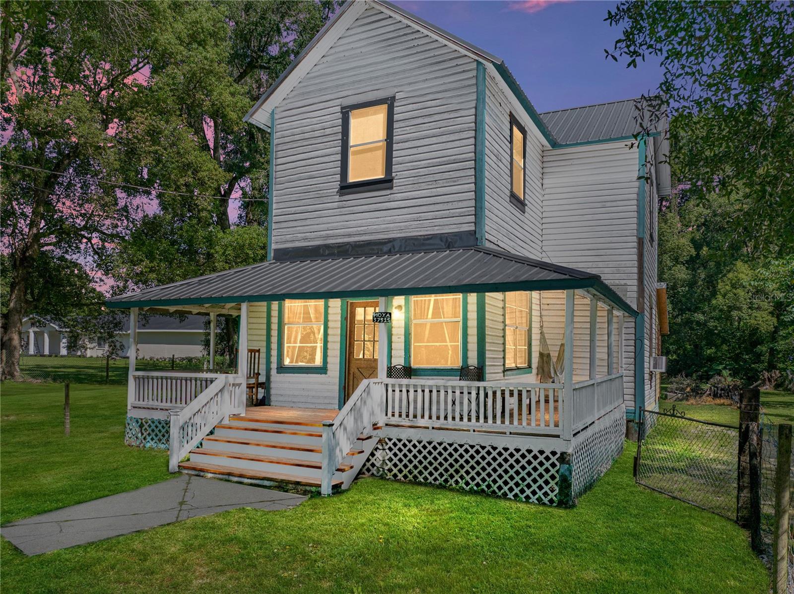 Nestled in the peaceful countryside of north Dade City, this 3 bedroom, 2 bath, two-story home
offers historic charm, a half-acre of land surrounded by mature trees, and endless possibilities for
restoration. Built in 1915, this fixer-upper is just waiting to be reimagined and brought back to its
glory days. Arrive to a fully fenced yard framed by towering shade trees and a classic wrap-
around porch. Inside, the comfortable living room flows into a character-filled dining space,
where soaring ceilings, an open staircase, and easy kitchen access create a warm, inviting hub for
daily life. The galley-style kitchen is generously sized with a cozy eat-in dinette, solid surface
countertops, and vinyl flooring. The first-floor is complete with a spacious primary bedroom and
a full bathroom. Upstairs, an open loft provides a flexible bonus area, perfect for an office or
lounge. Two 13x13 bedrooms share a centrally located full bath, completing the upper level!
Outside, relax and unwind on a full 1/2 acre of lush green property featuring a large workshop
with covered parking, a laundry shed, and a kennel enclosure that could easily be refreshed.
Recent updates include a 7-year-old metal roof, an updated electrical panel, and a well and septic
system (drain field replaced 7–10 years ago). Located close to the Croom
Trail, local churches, and the post office, this peaceful rural retreat combines small-town charm
with the opportunity to create a truly captivating country home. Call us today to learn more!