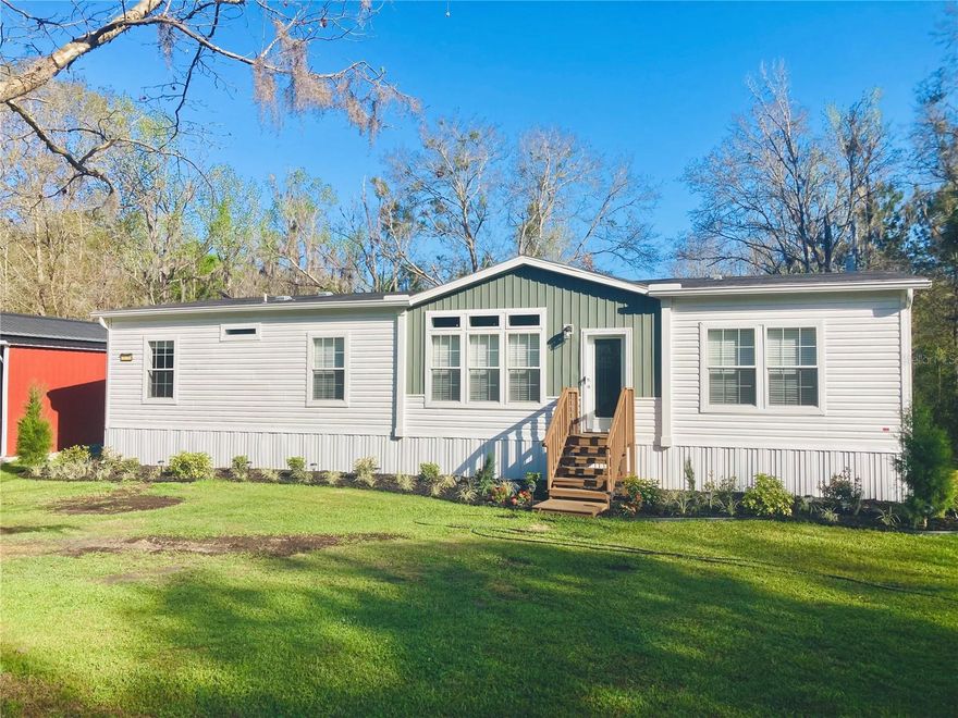 Nestled on 3 peaceful acres in the heart of North Central Florida, this unique property offers space, privacy, and incredible potential just minutes from historic downtown Micanopy and conveniently located 20 minutes to Gainesville, 20 minutes to Ocala, and only 15 minutes to the World Equestrian Center.

Built in 2024, the property features a spacious 4-bedroom, 2-bath manufactured home with 9-foot ceilings and 1,875 square feet of comfortable living space. Thoughtfully designed with custom upgrades throughout, the home includes an oversized walk-in shower in the primary en-suite, a built-in hall tree, added cabinetry above a built-in craft/office desk, and a generously sized walk-in pantry located just off the dedicated laundry room. The kitchen features all newer appliances and a large center island, perfect for gathering and entertaining.

Surrounded by mature trees and open land, this property provides the quiet country lifestyle many buyers are searching for while still offering convenient access to town, shopping, and major roadways. Whether you're looking for a private homestead, an investment opportunity, or land with utilities and flexibility to add an accessory dwelling unit, this acreage offers exceptional value in a highly desirable rural location.

The newly built (2025) metal garage building adds incredible functionality, featuring an 18' x 30' fully enclosed garage on a 19' x 31' concrete slab with front and rear roll-up doors for convenient drive-through access. The structure also includes a 12-foot lean-to on both sides, creating a total covered footprint of approximately 44' x 30', perfect for equipment, vehicles, storage, or workshop space.

With acres of usable land, there is ample room for equipment, recreational vehicles, livestock, gardening, or additional structures. The setting offers the perfect balance of privacy, nature, and rural charm, making it ideal for buyers seeking space and freedom outside city limits.

Enjoy peaceful North Florida living with room to grow, room to roam, and endless possibilities.  

Previously used as a hobby farm with goats and chickens.  Chicken coup and animal pen remain. Starlink available.