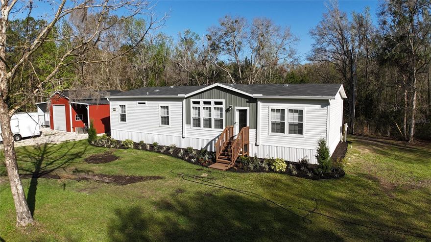 **Price Improvement – Exceptional Value!**

Now offered at $369,000, this property presents a rare opportunity to secure a home priced competitively within the current market. Thoughtfully positioned to attract immediate interest.

Nestled on 3 peaceful acres in the heart of North Central Florida, this unique property offers space, privacy, and incredible potential just minutes from historic downtown Micanopy and conveniently located 20 minutes to Gainesville, 20 minutes to Ocala, and only 15 minutes to the World Equestrian Center.

Built in 2024, the property features a spacious 4-bedroom, 2-bath manufactured home with 9-foot ceilings and 1,875 square feet of comfortable living space. Thoughtfully designed with custom upgrades throughout, the home includes an oversized walk-in shower in the primary en-suite, a built-in hall tree, added cabinetry above a built-in craft/office desk, and a generously sized walk-in pantry located just off the dedicated laundry room. The kitchen features all newer appliances and a large center island, perfect for gathering and entertaining.

Surrounded by mature trees and open land, this property provides the quiet country lifestyle many buyers are searching for while still offering convenient access to town, shopping, and major roadways. Whether you're looking for a private homestead, an investment opportunity, or land with utilities and flexibility to add an accessory dwelling unit, this acreage offers exceptional value in a highly desirable rural location.

The newly built (2025) metal garage building adds incredible functionality, featuring an 18' x 30' fully enclosed garage on a 19' x 31' concrete slab with front and rear roll-up doors for convenient drive-through access. The structure also includes a 12-foot lean-to on both sides, creating a total covered footprint of approximately 44' x 30', perfect for equipment, vehicles, storage, or workshop space.

With acres of usable land, there is ample room for equipment, recreational vehicles, livestock, gardening, or additional structures. The setting offers the perfect balance of privacy, nature, and rural charm, making it ideal for buyers seeking space and freedom outside city limits.

Enjoy peaceful North Florida living with room to grow, room to roam, and endless possibilities.  

Previously used as a hobby farm with goats and chickens.  Chicken coup and animal pen remain. Starlink available.