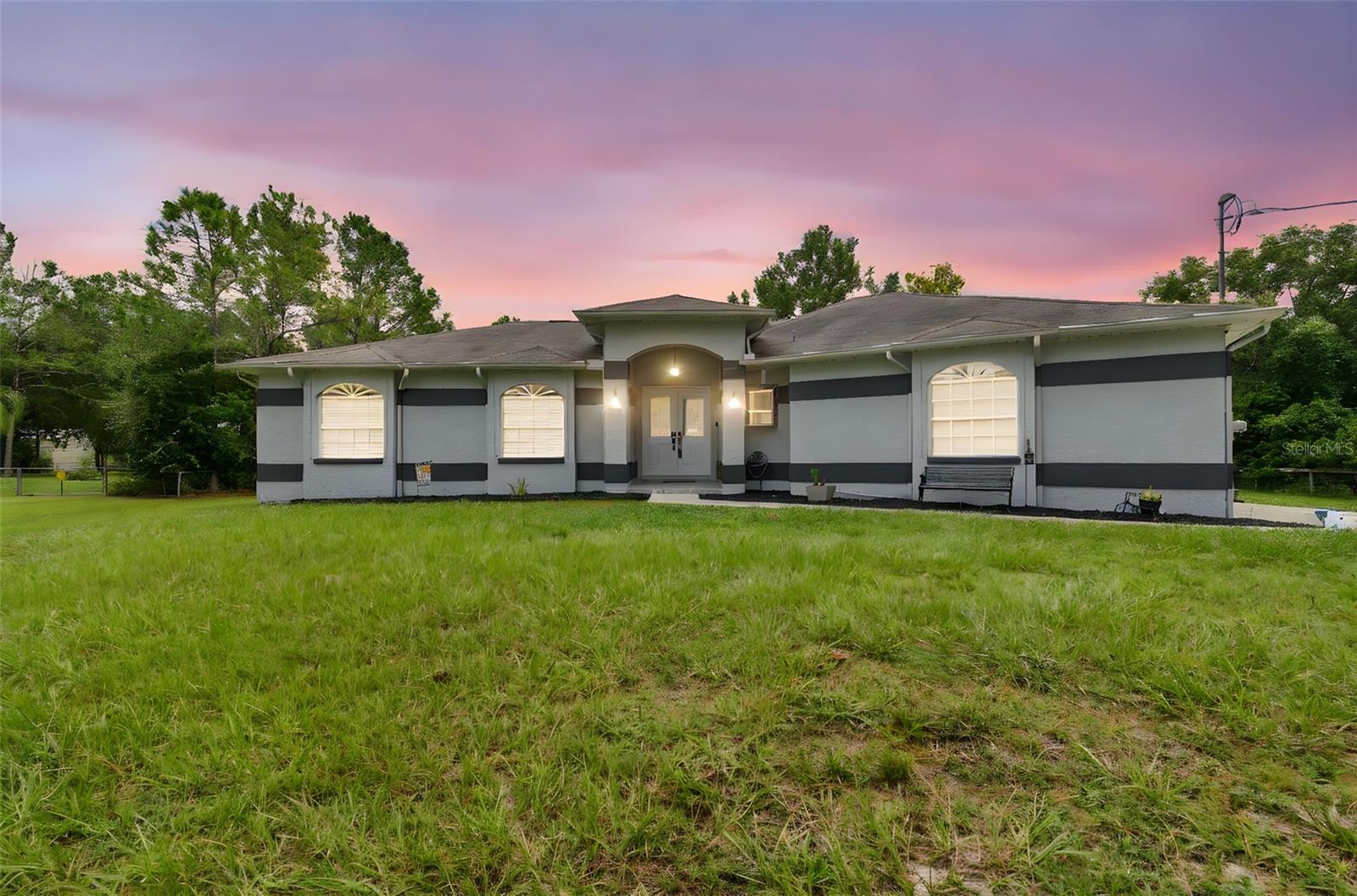 Designed with all generations in mind, this home combines thoughtful accessibility features with the potential for future expansion. Elevated above the lot and carefully graded, to assist with drainage, durability, and lasting comfort.
Set on over an acre of stunning land with a wooded backdrop, this residence offers a rare balance of privacy, versatility, and modern living. Inside, an open-concept layout seamlessly connects the living, dining, and kitchen areas, creating a welcoming space for both everyday life and entertaining. Featuring 4 bedrooms and 3 full bathrooms, including TWO SPACIOUS PRIMARY SUITES, the floor plan supports multigenerational living, visiting guests, or a high-end home office. One suite boasts a private entrance, ideal for in-law accommodations, guest privacy, or potential rental income. Bonus room has a mini split-system air conditioner and privacy doors with an abundance of natural light,
Two bathrooms are handicap accessible, and the continuous flooring throughout provides ease of movement from room to room. An attached 2-car garage ensures secure parking and extra storage, while the expansive grounds invite endless possibilities, from a pool or RV/boat parking to a workshop, garden, or creative outdoor space.
Experience the serenity of country living with modern convenience, just minutes from major highways, hospitals, shopping, and a wide variety of dining options. Here, you enjoy the best of both worlds: tranquil surroundings and easy access to everything you need.
The home is equipped with a whole-house water softener, and the A/C, well, and septic systems are meticulously maintained for your peace of mind. NO HOA, NO CDD, NO Deed Restrictions—providing the ultimate freedom to customize your property and lifestyle.
