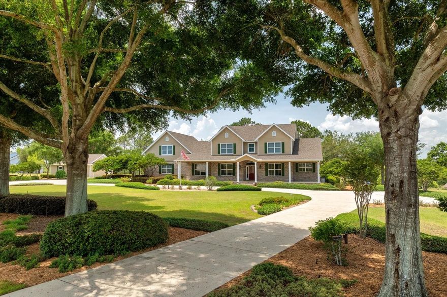 Step into a world of timeless elegance at this custom-built 4,281 sq ft masterpiece on 2.57 private acres at one of Montverde’s highest elevations. This 4-bedroom, 2-full-bath, 3-half-bath estate, crafted by an award-winning builder, redefines luxury with its extraordinary landscaping, featuring majestic mature Oak trees and vibrant, year-round blooming gardens that create a secluded paradise. An expansive paved driveway sweeps through the grounds, offering multiple parking options and leading to an oversized 3-car garage with 8’ doors and a separate 2-car garage/workshop with HVAC and half-bath—up to 5 garage spaces for collectors or hobbyists.
Ascend the steps to an inviting open patio, perfect for grand entertaining, or retreat to the vast screened lanai, where breathtaking vistas of the treed landscape unfold, blending indoor and outdoor living. Inside, white oak flooring, Silestone quartz countertops, and custom cabinetry set a tone of refined sophistication. The gourmet kitchen, a chef’s dream, boasts a large walk-in pantry and premium appliances, flowing seamlessly into a cozy family room with a gas fireplace and built-in cabinetry. The downstairs primary suite offers serene privacy, while three generously sized upstairs bedrooms—far exceeding standard dimensions—provide luxurious retreats. A versatile second-story flex space awaits transformation into a home theater, private gym, or bespoke lounge, ensuring the home evolves with your lifestyle.
Additional highlights include a large unfinished bonus room over the 3-car garage, ripe for customization, and meticulous details like crown molding, 5.5” baseboards, window casings, and extensive storage throughout the house. Climate control is effortless with 3 AC units for the main house and a split HVAC for the workshop. In the backyard is a pergola covering the outdoor kitchen grill, 2 burner cooktop and sink.  NO HOA!!  Zoned for horses, this estate is an equestrian’s haven, yet it’s just minutes from Montverde Academy and Bella Collina with world-class amenities, including golf, spa, and fine dining. More than a home, this is a legacy of prestige, privacy, and unparalleled craftsmanship. Schedule your private tour to experience Montverde’s finest.