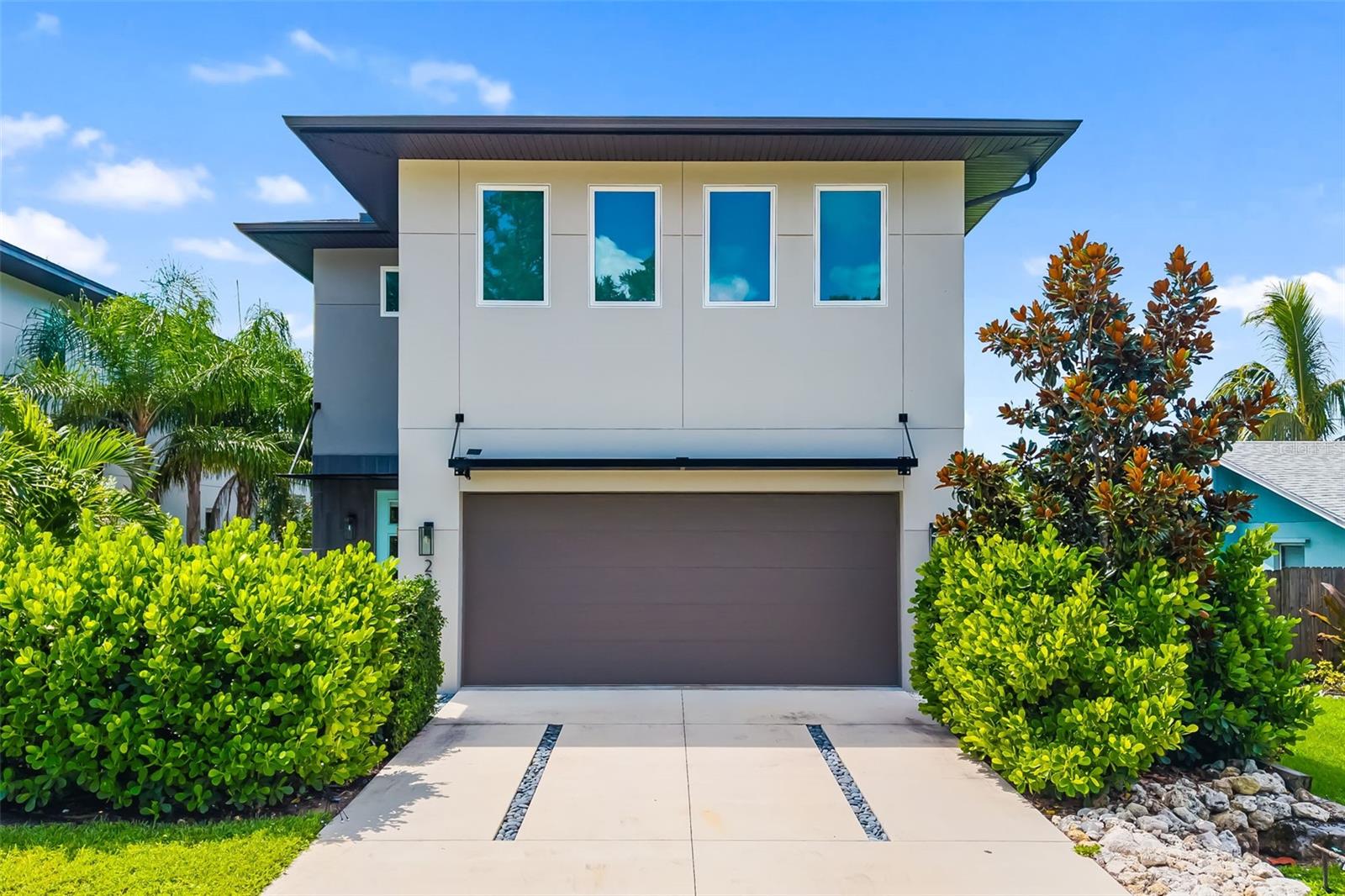Discover modern luxury in this private and serene 4-bedroom, 2.5-bathroom pool home, built in 2021 and designed for today’s lifestyle. Spanning 2,875 sq. ft., this contemporary residence offers the perfect blend of architectural elegance and everyday comfort.
From the moment you enter, soaring ceilings and polished concrete floors set the tone for a sleek yet inviting atmosphere. The open-concept floor plan flows effortlessly, with walls of glass that flood the home with natural light and create a seamless connection between the indoor living spaces and the outdoors. The gourmet kitchen is a true showpiece, featuring a striking quartz waterfall island, high-end cabinetry, and a complete Bosch appliance suite. Whether preparing a casual meal or hosting friends, this space is designed to impress. The adjacent dining and living areas are open and airy, designed for both intimate evenings and lively gatherings. Upstairs, a versatile loft provides flexible space for a home office, media room, or lounge. The primary suite is a retreat of its own, with dual walk-in closets, a private terrace overlooking the pool, and spa-like finishes for the ultimate escape. Three additional bedrooms offer comfort and space for family or guests, each thoughtfully designed with style and functionality in mind. Every detail has been considered, from premium finishes and custom touches to hurricane-impact windows and advanced storm protection for peace of mind. Step outside to an incredible outdoor oasis featuring a cageless pool, expansive sundeck, and lush tropical landscaping—perfect for relaxing, entertaining, or enjoying Sarasota’s year-round sunshine. Offered furnished, this residence is move-in ready and designed to complement Sarasota’s vibrant coastal lifestyle. This is more than a home—it’s a modern sanctuary where luxury, privacy, and Sarasota’s best amenities come together. Ideally located just minutes from Sarasota’s #1-rated beaches, world-class restaurants, and premier shopping. Call today for your private showing. Home is being sold fully furnished.
