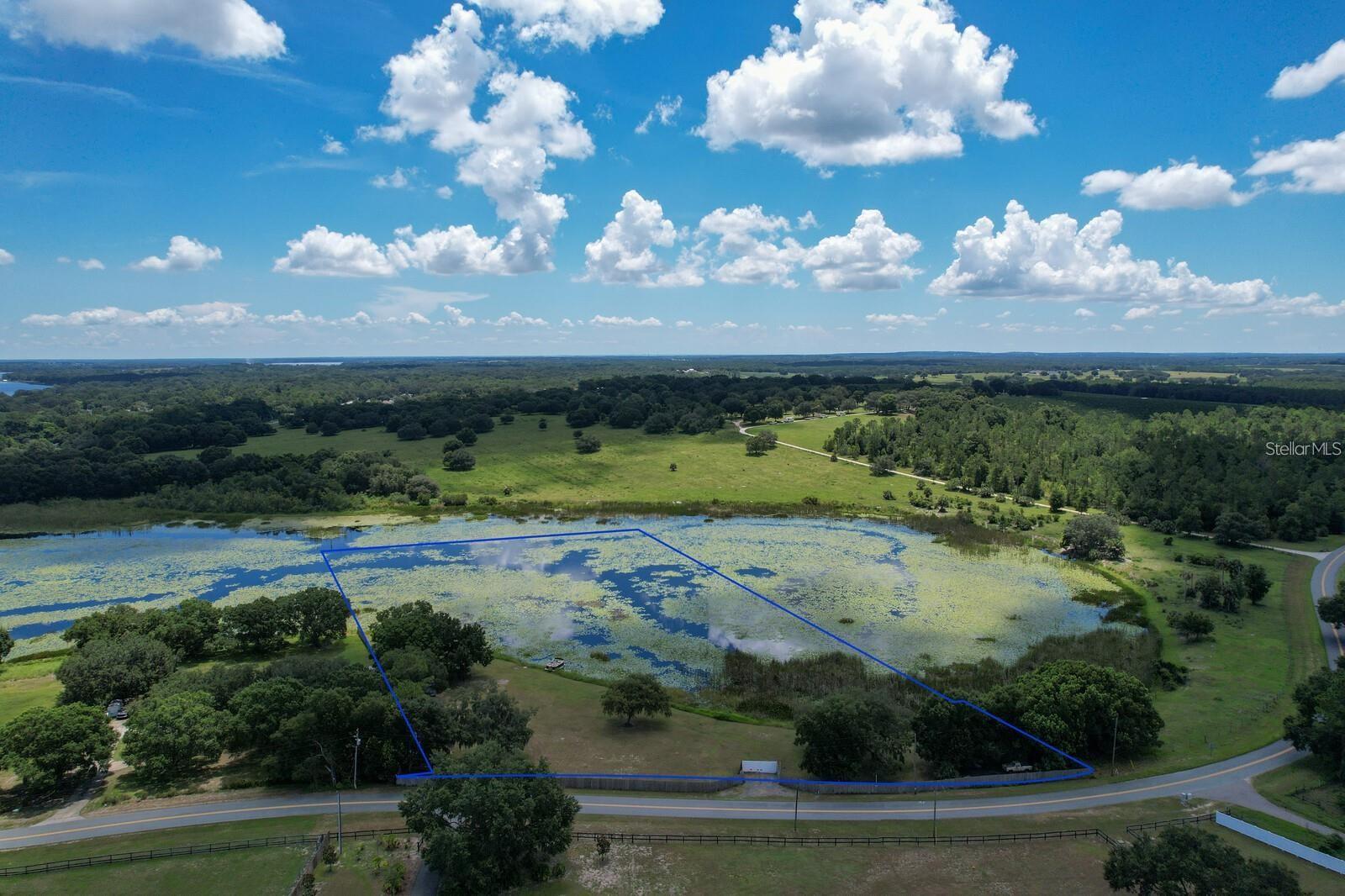 Come discover this rare opportunity on Number Two Road. Right here in Yalaha, Florida. —nearly 4 acres of stunning lakefront land, including approximately 2 acres high and dry and ready for your dream build (approved plans available) . Whether you envision a custom home, workshop, or both, this property provides the space and freedom you’ve been searching for. With no HOA, a fully fenced and gated entrance, a newer well with pristine water, and electric service already on site, the groundwork has been set for your vision. The private lake is stocked with trophy bass, making this a true fisherman’s paradise. Shown by appointment only, this property must be seen to be fully appreciated. Behind the gates you’ll find peace, privacy, and endless potential. No personal property conveys with the sale. Make this your Number One choice, on Number 2 road, for lakefront living in Yalaha!