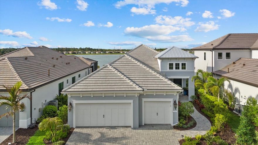 You won't want to miss this one......Indulge in the epitome of lakeside luxury at The Alcove at Waterside by Neal Signature Homes, an exclusive enclave within the vibrant Waterside District of Lakewood Ranch. This stunning residence offers three bedrooms, three full baths, a private den, and 2432 square feet of thoughtfully designed living space with IMPACT RESISTANCE GLASS AND SLIDERS! This beautiful home has a private saltwater pool with LED lights and a large covered lanai area measuring 28 x 17 feet. Plumbed for an outdoor kitchen and comes with electric hurricane screens to give you that peace of mind you are wanting. 
Inspired by a Coastal architecture, the home showcases elegant stucco exterior, a classic tile roof, and refined architectural details. Inside, elevated design touches abound, including custom ceiling treatments, designer wallpaper, and plantation shutters, creating a sophisticated yet relaxed coastal ambiance.
Seamlessly blending indoor and outdoor living, custom 10-foot-high by 12-foot-wide sliding glass doors open to the outdoor living space and frame picturesque views of Blue Heron Lake, filling the home with natural light. Enjoy evening sunsets like you have never seen from your beautiful lanai overlooking the lake.
Additional upgrades include a whole-house Kohler generator for peace of mind, mini-split air-conditioning system in the garage, insulated garage doors, custom ceiling treatments inside and out, automatic sun shade, shell stone pavers that are cool to the touch and additional storage in the garage.
Perfectly located just one mile from the coveted Waterside Place Village, residents enjoy easy access to waterfront dining, boutique shopping, farmers markets, and community events. Center Point at Waterside is only 1.5 miles away, offering even more popular lunch and dinner destinations along with everyday conveniences.
With breathtaking lake views, thoughtful upgrades, and an exceptional location in one of Lakewood Ranch’s most desirable areas, this remarkable home offers luxury living and lifestyle at its finest — and so much more to discover.