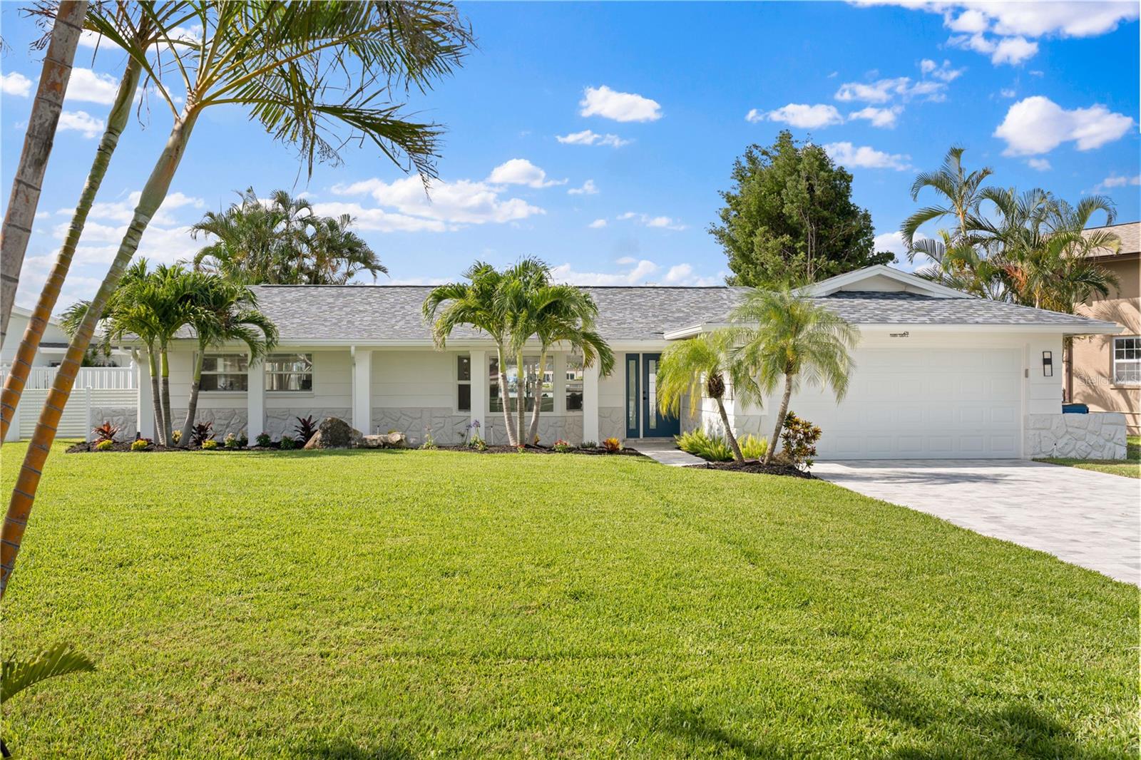WATERFRONT LUXURY ON PARADISE ISLAND
Welcome to your coastal-chic stunner in the heart of Treasure Island’s desirable Paradise Island. Set on an oversized corner lot along a beautifully landscaped boulevard, this modern single-level retreat has been thoughtfully reimagined with luxury finishes and exceptional attention to detail—offering the ultimate boater’s lifestyle just minutes from the Gulf of Mexico.
From the moment you arrive, you’ll notice the curb appeal—lush tropical landscaping, swaying palms, custom lighting, and wide paver walkways all guiding you to the front door. Step inside to panoramic water views that immediately steal the show. The open floor plan flows effortlessly with walls of floor-to-ceiling hurricane-impact windows and sliders (2024), and sleek 40x40 ceramic tile floors (2025) that stretch throughout the home.
The chef’s kitchen is a dream—completely renovated in 2025 with shimmering quartz counters, solid wood custom cabinetry, high-end stainless appliances, and a stylish entertaining bar. Adjacent to the kitchen, a sunny eat-in nook invites you to linger—perfect for reading the morning headlines, journaling, or diving into a creative project while basking in natural light. A formal dining space also overlooks the pool and waterway, ideal for sunset dinners with friends.
The living area is bright and breezy, complemented by a built-in dry bar with designer cabinetry for effortless entertaining. The smart split-bedroom layout provides privacy for all, with the primary suite tucked away in its own wing. Here you’ll find stunning views, private access to the patio, and a spa-like ensuite featuring a soaking tub, dual vanities, and luxe finishes throughout. A second bedroom or home office shares those same dreamy views, while a third guest suite includes its own private bathroom—ideal for visitors or multigenerational living.
Both bathrooms have been completely transformed with elegant coastal tones, quartz countertops, glass-enclosed showers, and high-end fixtures. Every detail is elevated—from new baseboards and doors to lighting, hardware, and redesigned exterior columns.
Step outside and fall in love with your private tropical paradise. The resurfaced Pebble Tec pool sparkles beneath the sun, surrounded by a brand-new paver deck (2025) for lounging, dining, or soaking in the peaceful vibe. Take your morning quiet time out to the dock—watch dolphins play while sipping your favorite drink or simply enjoy the silence as boats glide by. For boaters, this property is a gem: featuring a new seawall, 10,000 lb. lift, and deep-water canal with easy access to open water.
Additional upgrades include a hurricane-rated garage door, new soffits and fascia, upgraded insulation, and a modern rain drainage system designed for durability and peace of mind. Flood insurance is required, but major mitigation steps have already been handled.
Located just minutes from Treasure Island Beach, local shops, waterfront restaurants, and the Treasure Bay Golf & Tennis Center, you’re perfectly positioned to enjoy everything this vibrant coastal community has to offer. Cruise around on your bike or golf cart, or take a quick trip into downtown St. Pete for world-class dining and arts.
24 Marina Terrace isn’t just a home—it’s your personal retreat where luxury meets lifestyle. Schedule your private showing today and start living the waterfront dream.