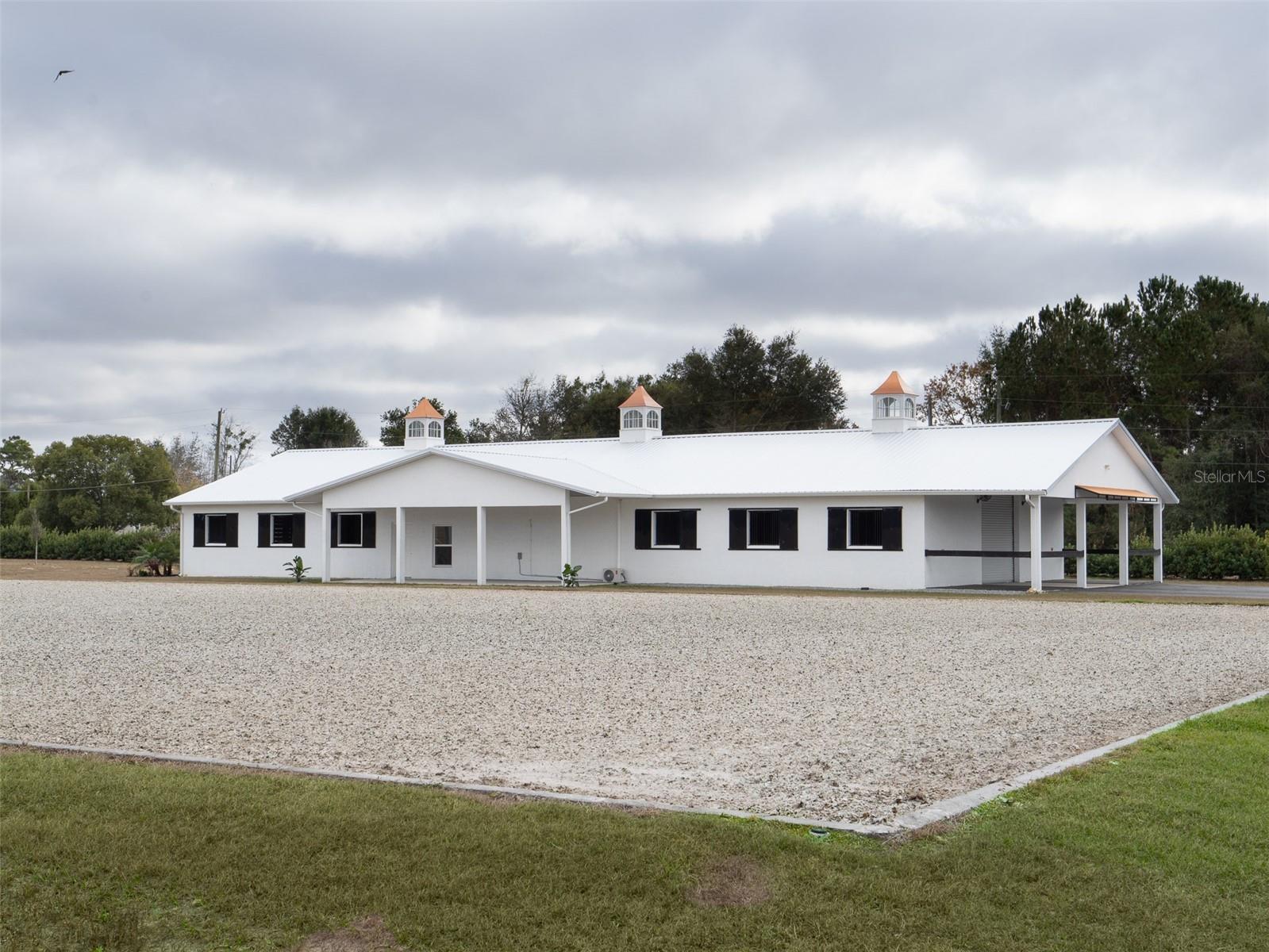 This fully fenced,10.01-acre property in Ocala is just 8 minutes from the World Equestrian Center and 10 minutes from HITS! It features five spacious paddocks ideal for grazing or exercise. The well-built block barn includes 12 stalls with excellent ventilation, a tack room, two wash/groom stalls, and a laundry room, providing all the essentials for horse care. A comfortable office and kitchenette make managing operations easy, and the barn also includes 1.5 bathrooms for added convenience. The property includes a 100x200 synthetic surface arena with a concrete border and irrigation, providing a perfect setting for training. Whether you're a competitive rider, trainer, or equestrian enthusiast, this property offers everything you need for success, making it an outstanding opportunity to own a premier piece of Ocala’s equestrian scene.