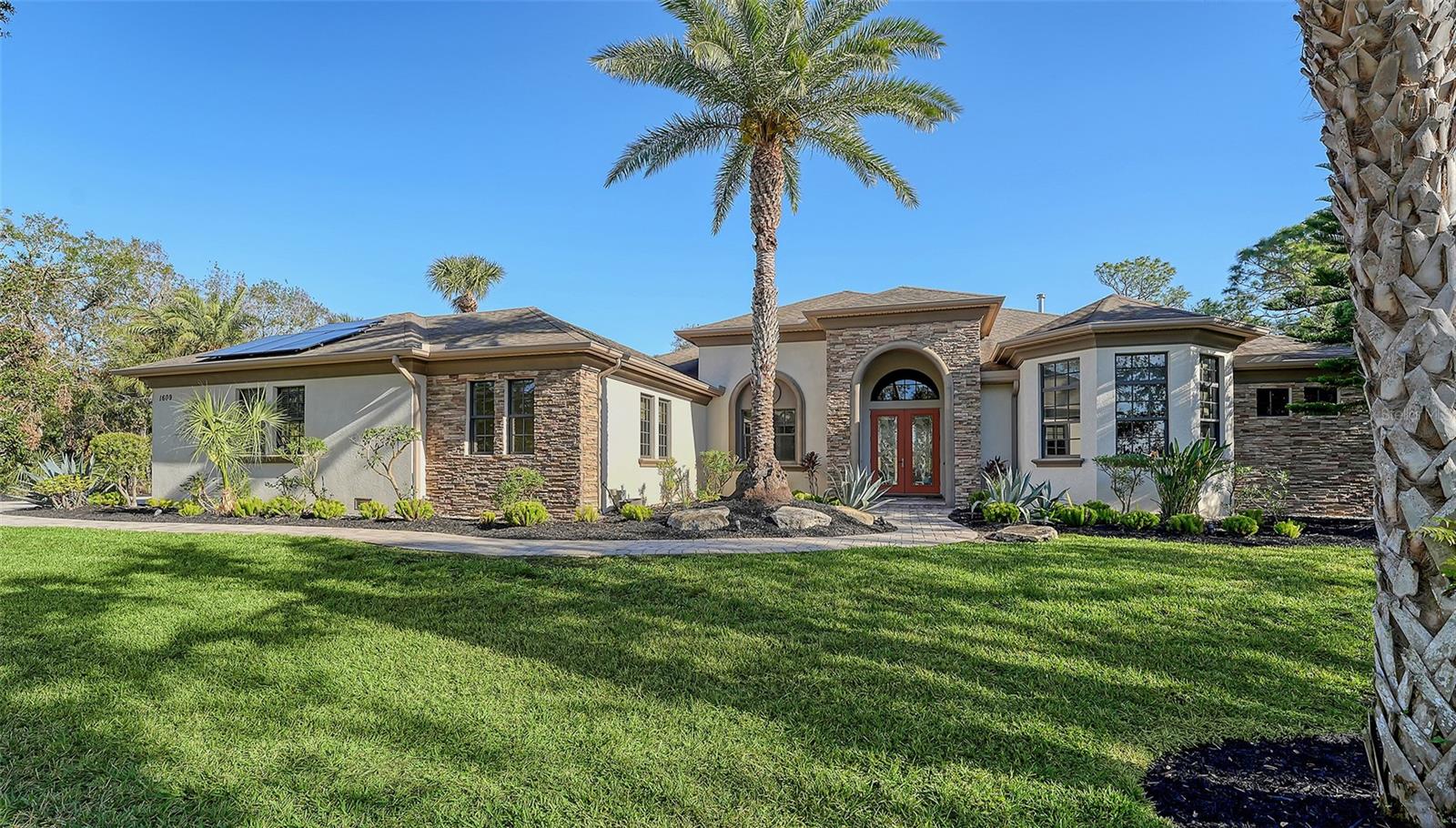 Third Price Reduction!! SERENITY!!! This is what you will experience at this beautiful home on 1609 Palm View in Oak Ford. Just 15 minutes from Terra Nova Equestrian Center and 15 minutes East from the UTC Mall congestion and traffic surrounding that area. You will feel a world apart and experience the beauty, serenity, peace and natural beauty of this gorgeous area and exquisite turn-key furnished home. This Beautiful Arthur Rutenberg pool home is located in The Oak Ford community off Fruitville Rd east of I-75. Solar panels provide electricity for the entire home and heated pool which has an automatic self-cleaning system. This stunning all on one floor home has a very private large lot surrounded by lush natural beauty with expansive views. As you enter through the beautiful double beveled glass front doors into the tiled foyer you will be immersed into exquisite quality of design with high ceilings and crown molding throughout the entire home. Hurricane rated sliding glass doors and windows throughout. The Great Room features beautiful tiled floor and lovely furniture and a stacked stone gas fireplace with granite mantle, flat screen TV & sound bar. The Great room looks out to the screened lanai and heated pool with newer heat pump and tranquil water feature. The lanai also features a granite wet bar area, GE Monogram beverage refrigerator. The lanai features pavers which are also on the driveway and walkway leading up to the front door. Custom blinds throughout. Whole house saltwater system for all of the water in the house. And an Osmosis system in the kitchen for clean drinking water. The lanai has an automatic remote control awning for shade as you lounge on the couches and enjoy the serenity and tranquility of the backyard. The Den/Flex room in the house has hardwood floors and is off the Great room and features recessed lighting with furniture to relax on. The primary bedroom has its own entry way with privacy doors as well as a Trey Ceiling. Two large walk-in closet provide lots of room for clothes and accessories. Hunter Douglas remote controlled shades are on the windows and the primary bedroom is totally furnished along with having a separate HVAC. The primary bathroom features a large soaking tub and a walk-in shower with two shower heads and tiled surroundings. Separate granite double vanities offered in this spacious bathroom. Absolutely gorgeous kitchen has a large hidden walk-in pantry behind cabinet doors and additional pantry gives you plenty of storage. Mahogany cabinets throughout the kitchen with dark granite countertops. Stainless Steel new GE Monogram oven, microwave and dishwasher, Bosch SS Refrigerator and wine refrigerator in kitchen under the coffee/beverage bar. The laundry room features Maytag washer and dryer and cabinetry and counter space with a second refrigerator in this area. Extra storage closet just off the laundry room for cleaning supplies/storage. The home office has hardwood floors and the house features a whole house alarm system and lots of outdoor lighting. There is a pool bath on the lanai and a full bath between 3rd bedroom and the office. This house utilizes a well so there is no water bill and has an automatic water sprinkler system and outside lighting system. Sarasota county has A rated schools, world renowned beaches and lots of excellent restaurants. New Publix, Aldi, CVS and more only minutes away. Enjoy it all and beautiful country living that affords you peace and quiet.