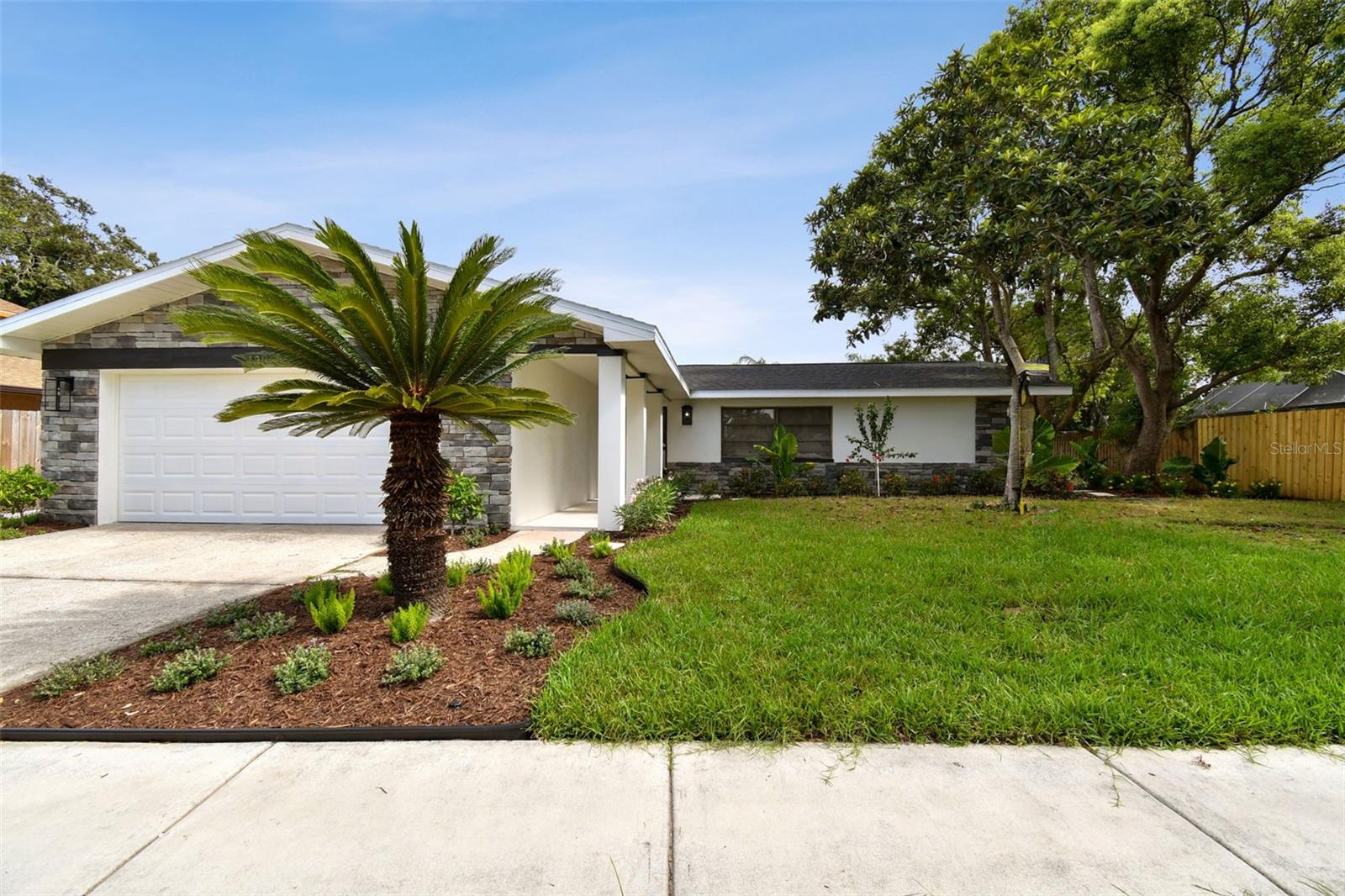 Under contract-accepting backup offers. ACCEPTING BACK UPS.....Here’s your chance to own a beautifully reimagined home in one of Palm Harbor’s most desirable neighborhoods—where short-term rentals are allowed, no HOA and location is everything. Whether you’re searching for the perfect primary residence or a savvy investment, this property checks every box.
As you arrive, you’ll immediately notice the brand-new roof, distinctive stonework façade, and meticulously designed landscaping that set this home apart from all the rest. A custom-tiled walkway leads you to the entrance, setting the tone for what lies ahead.
Step inside and experience professionally curated luxury finishes throughout. From the custom roman shades, wide-plank luxury vinyl flooring to the show-stopping kitchen featuring quartz countertops, imported stone backsplash, caviar colored cabinetry with gold pulls, and brand-new stainless steel appliances, every inch has been thoughtfully upgraded. The specially designed sitting area features a coffee / liquor bar with custom wall paper to enhance the luxury look of this home.
The private primary suite is located on the west wing, complete with a fully remodeled en suite bath adorned with premium imported tile. On the opposite side, you’ll find another spacious bedroom and a second custom-designed full bath—ideal for guests or family.
The two-car garage provides plenty of storage and parking, but the true highlight is out back. Slide open the dual set of disappearing glass doors to reveal an oversized screened lanai with the same custom tile work as the front entry.Truly making the outside come in.The screened lanai is an entertainers dream with plenty if room and a pass through to the kitchen. The backyard is a private oasis, featuring new 6-foot privacy fencing, fresh sod, and ample room to entertain, relax, or simply enjoy the Florida lifestyle. Priced to sell, schedule your private showing ASAP!