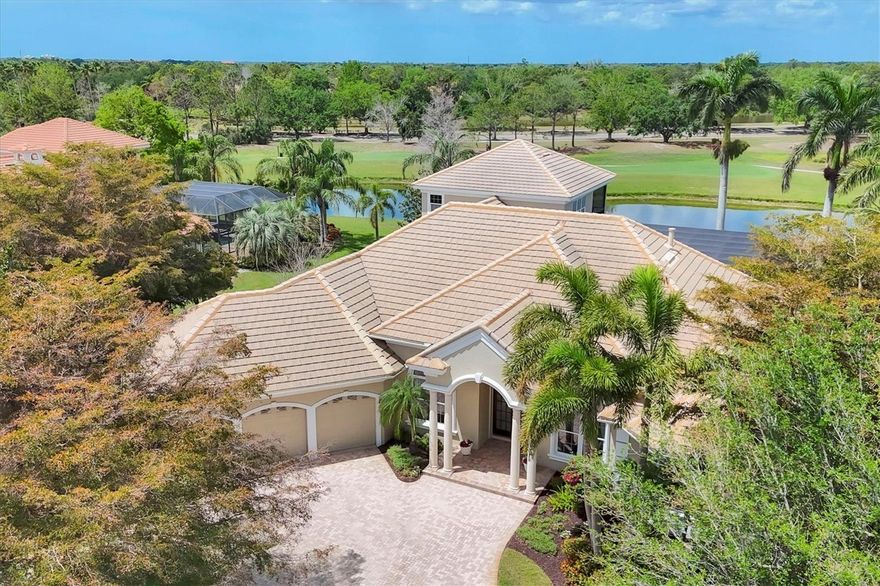 Under contract-accepting backup offers. Welcome to Portmarnock Place – an enclave that is home to some of the most stately properties in the Lakewood Ranch Country Club. Offered for the first time, this custom-built residence was created by the sellers and Pruett Builders to take advantage of the expansive views while providing a refined and elegant environment. Set on a generous half-acre lot on the 18th hole, this perfectly positioned home showcases long water, fairway and preserve views. As you approach the home you are greeted by a circular driveway and lush, mature landscaping. The grand double doors invite you in where you are presented with 12 foot ceilings, an ethereal living room with fireplace and built-ins, and a wall of glass framing the beautiful views that await. Fine architectural details grace most every area of this home – from lighted double and triple tray ceilings to feature walls and custom cabinetry, fine craftmanship is evidenced everywhere. If you enjoy entertaining you will find multiple areas to gather here – the elegant dining and main living rooms, adjacent wet bar with wine cooler, expansive family room, recreation room and multiple outdoor gathering areas provide ample options for family and guests. Accessing the outdoor space is made both easy and beautiful with 6 walls of the home featuring sliding glass doors that move completely out of view, essentially combining both indoor and outdoor environs. Once outside you’ll enjoy making and sharing memories by the heated salt-water pool and spa, the cozy conversation area by the fireplace and outdoor kitchen, and the intimate setting for two beyond the lanai where sunsets and sunrises are the main attraction. Inside you’ll enjoy preparing culinary creations in the expansive kitchen featuring high-end KitchenAid and Bosch appliances, custom-crafted cabinetry, large walk-in pantry, expansive counter space including a prep island, and plenty of seating. There’s even an additional seating area with a window seat and views through the aquarium glass to the pool area. When it’s time to end the day, you’ll find the owners’ suite, set apart at the opposite side of the home, is a comforting retreat. Behind the tall double doors is a spacious sleeping area with access to the lanai. Attached to this space behind double French doors is a private reflection and reading room, awash in natural light with a floor-to-ceiling custom bookcase. No luxury suite is complete without a generous spa-like bath, and you’ll find that here too. At over 4,700 square feet of living space under air, this residence comfortably offers 4 bedrooms, 4 full baths, oversized closets (several are walk-in), large laundry/workroom combo, a formal office/den with double French doors and a wall of built-ins, an upstairs living suite with a terrace featuring endless views, and a generous 3-bay garage with ample storage. The Lakewood Ranch Country Club offers extraordinary state-of-the-art amenities through membership choices – 4 golf courses, an aquatic and racket sports center, fitness facility and multiple dining options at the three clubhouses. Being a top master-planned community in the U.S., Lakewood Ranch puts its fortunate residents in the middle of endless dining, shopping, recreational and cultural options. Come experience for yourself what a coveted lifestyle can mean for you!