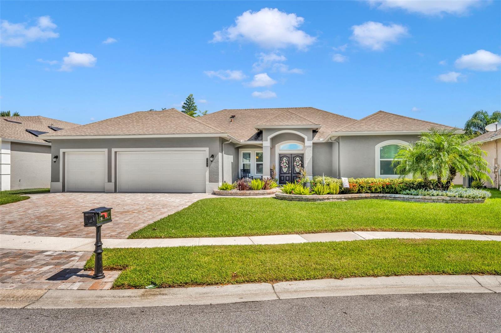Welcome to this beautifully upgraded 4-bedroom, 3-bath home with a separate office and an oversized 3-car garage, nestled on a quarter acre manicured lot in the sought-after gated enclave of Howell Creek Reserve in Tuscawilla. From the moment you arrive, you’ll be captivated by the impeccable curb appeal, lush landscaping, and brick-paver driveway that set the tone for the elegant lifestyle that awaits. Inside, soaring ceilings and a spacious open floor plan create a bright and inviting atmosphere. A dedicated office with classic French doors offers the perfect space for working from home or could easily serve as a playroom or flex space. The home features a desirable three-way split bedroom layout, providing privacy and comfort for family and guests. The expansive island kitchen is a chef’s dream with granite countertops, freshly painted cabinets, newer stainless steel appliances, and a huge walk-in pantry. A cozy breakfast nook overlooks the serene backyard gardens and opens seamlessly to the generous living and dining areas, ideal for entertaining. No detail has been overlooked—enjoy wood-look tile flooring throughout, plantation shutters, upgraded baseboards, and crown molding. The custom stone accent wall with a sleek electric fireplace (2022) adds warmth and modern style to the living space. The luxurious owner’s suite boasts a tray ceiling, large windows with plantation shutters, and a spa-inspired bathroom complete with dual vanities, soaking tub, separate shower, quartz counters, and a massive walk-in closet. Additional upgrades include: • New roof and gutters (2018) • Upgraded bathrooms with custom tile and new fixtures • New energy-efficient windows, sliders, and back doors (2020) • New AC system, soffits, garage doors, and exterior paint (2021) • Custom landscape lighting and beautifully designed gardens with stone accents (2021) • Stunning double front doors and a tranquil front fountain • Screened-in lanai and an expansive brick-paver patio, perfect for outdoor entertaining
The fully fenced backyard feels like a private oasis, featuring lush landscaping, raised garden beds, and ample space for gatherings or play. As part of the Howell Creek Reserve community, enjoy access to a resort-style pool, cabana, playground, basketball court, neighborhood fishing ponds and walking distance to the Cross Seminole Trail. All this, plus the incredible lifestyle and amenities of the Tuscawilla Community. This is more than a home—it’s a lifestyle. Come fall in love today.