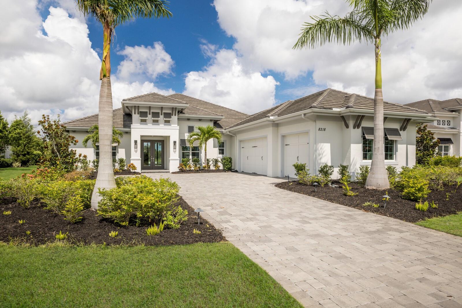 Experience sunsets over the lake from this Sterling III residence inside the exclusive gated community of The Lake Club in Lakewood Ranch. Encompassing 3,829 square feet of open one-story living, this custom Stock Home built in 2020 boasts generously sized indoor and outdoor spaces, volume ceilings, stylish finishes, and, of course, IMPACT windows/doors/sliders.
An expansive outdoor retreat elevates the Florida living experience with a panoramic screened lanai, extensive open and under cover spaces grounded with pavers, fully loaded summer kitchen with even a pizza oven, PebbleTec heated saltwater pool/spa with sun shelf, fireplace, and a serene lake view with sunsets delivered nightly.
Ten foot impact glass sliders seamlessly connect the outdoor oasis to a luxuriantly large great room, dining area and gourmet kitchen with sumptuous luxury plan vinyl crowned with soaring ceilings creating an open continuity of space. The kitchen further accentuates with white wood cabinetry, quartz counters, stainless steel appliances, and walk-in pantry.
Relax and unwind in the owner’s quarters positioned on a private wing, offering double tray ceilings, large scale windows, direct lanai access, wood flooring, two oversized walk-in closets, and an appointed spa-like bath with two vanity stations , an oversized shower, large soaking tub, and separate water closet. Family and overnight guests will appreciate the three additional guest suites, all generous in size, all with walk-in closets, two offer ensuite full baths, while the third guest room is just off the home’s fourth full bath.
An impressive club room directly off lanai beckons for entertaining with glorious views beyond, plus the residence delivers an impressive office behind double-entry doors just off the entry foyer. Other notable highlights of this all-encompassing 5,963 total square foot residence includes a brilliantly finished laundry room, a pool with auto-fill and auto-drain, all impact windows and doors, and an oversized three car garage with electric car charging station.
This newer and modern offering is the pinnacle of luxury living in The Lake Club, where residents enjoy access to a wealth of amenities, including two resort-style heated pools, Grande Clubhouse with fine dining and bar area, a fitness center, spa, tennis courts, pickleball, a playground, dog park, and services of a full-time concierge and activities director.