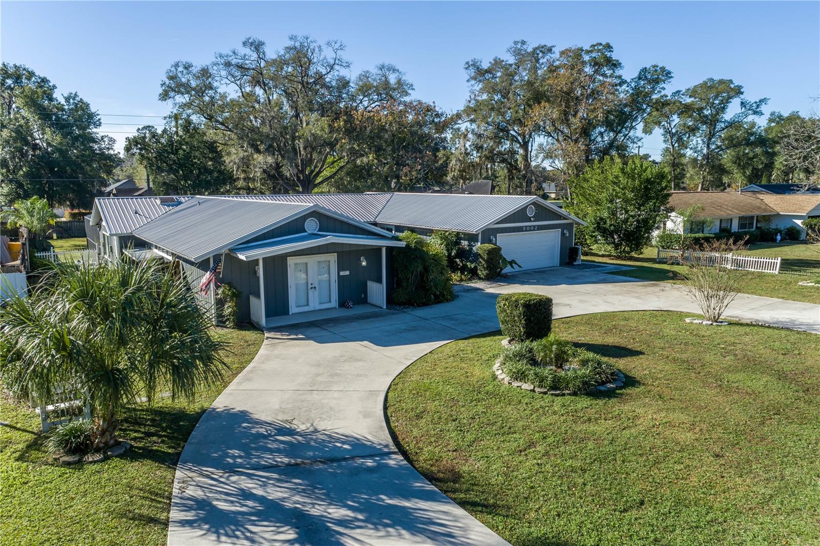 **NO HOA & NOT A FLOOD ZONE!** Look at this beautifully updated 5-bedroom, 3-bathroom home sits on a spacious .51-acre lot with street-to-street access and a double-gated, privacy-fenced backyard—perfect for storing your boat or RV. Featuring a triple-split floor plan with two primary suites, this home offers excellent flexibility for multi-generational living or a private in-law suite. Originally remodeled in 2016, the home boasts a lifetime metal roof, a modern kitchen with granite countertops, updated bathrooms, wood and tile flooring throughout, fresh interior and exterior paint, and a screened-in enclosure. Both A/C units and the water heater were also replaced in 2016. In 2017, an inground pool and an additional screen enclosure were added for year-round enjoyment. The oversized primary suite includes dual walk-in closets, dual vanities, and an expansive double shower. The driveway was redone in 2020, and a new garage door was installed in 2022. This move-in ready home is packed with upgrades and charm. No verbal offers will be considered or accepted.