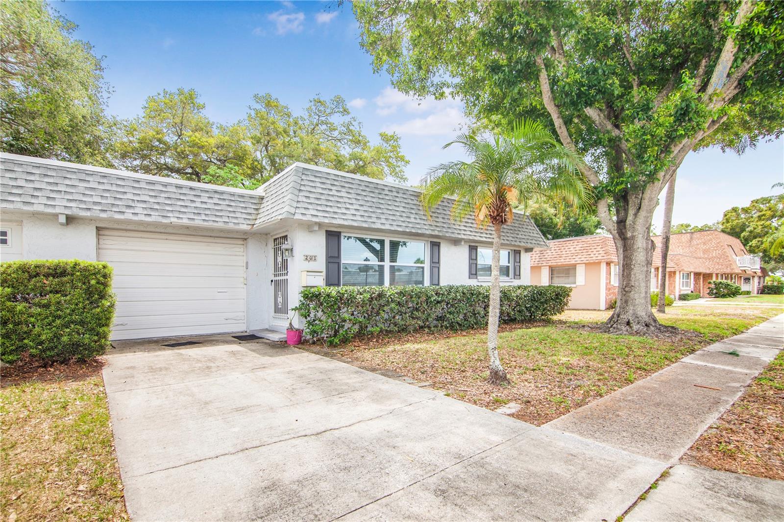RARE FIND - This beautiful 2/2/1, 55+ Condo offers a 1-Car ATTACHED Garage for added convenience, storage and security - which can easily store your car, beach essentials, holiday decor and washer/dryer (included). Upon entering this well-cared for unit; from either the garage entry into the Kitchen, or the main front door into the Living Room - you will LOVE the newly installed Woodlike-High-Quality Vinyl Flooring throughout (no carpeting) which is GORGEOUS and easy to clean & maintain! You will equally LOVE the Beautifully Upgraded Kitchen complete with Beautiful White Wood Cabinets and Upgraded Hardware, GORGEOUS Granite Countertops and Upgraded Stainless Steel Appliances. The Kitchen also offers a Window right above the sink; providing a perfect resting spot for your favorite home-grown herb sprouts, and a nice sized Eat-In Breakfast Bar. Directly off of the Kitchen is a Multi-Use-Space - great to use as a Den, Office or Additional Dining Space. Just off of the Kitchen is a wonderful outdoor Screened-In Lanai to enjoy our GORGEOUS Florida Weather Year Round. Off of the Lanai is also a nice sized Patio, all of which is very private and offers plenty of space for a patio set, grill, or your favorite potted plants. The Large Dining Room/Living Room Combo in the front of the unit is nice and bright with new Hurricane Rated Windows (ALL Windows Upgraded througought the home) and Beaufitul Wood Shelf Built-Ins for all of your personal design touches! The Large Master Bedroom offers Wall-to-Wall His/Hers Closets for your entire wardrobe, along with a Full Ensuite Bathroom. The 2nd Guest Bedroom is also a good size, with mple closet space and an adjacent Full Bath. This unit is NOT short on additional closet space with multiple linnen/storage closets throughout. Located in the Heart of Largo, FL, you will LOVE being close to the World-Class-Crystal-Blue-Water-Beaches of Clearwater and Indian Shores. You will also LOVE the fact that this private community is nestled quietly back from the hustle and bustle of East Bay Dr, yet you have all of the modern conveniences of shopping, dining and easy commuter access to all major routes (US-19N and I-275) right around the corner. You will also enjoy the close proximity to the Highland Recreation Center with a multitude of activiites and social events (https://www.playlargo.com/facilities/highland_recreation_complex/index.php) and the Florida Botanical Gardens Park with Beautiful Walking Trails and Stunning Lush Scenery! Additional features in this hard-to-find condo include Newer Roof (approx 2017), HVAC (2015), Newer Electrical Panel (Approx 2020) and Upgraded Appliances. This home can convey FULLY FURNISHED for Buyers Convenience - so all you truly need to pack is a bathing suit, coverup, and don't forget your tooth brush! Don't delay on this Desirable Condo, Call Today for your Private Showing and Welcome Home!