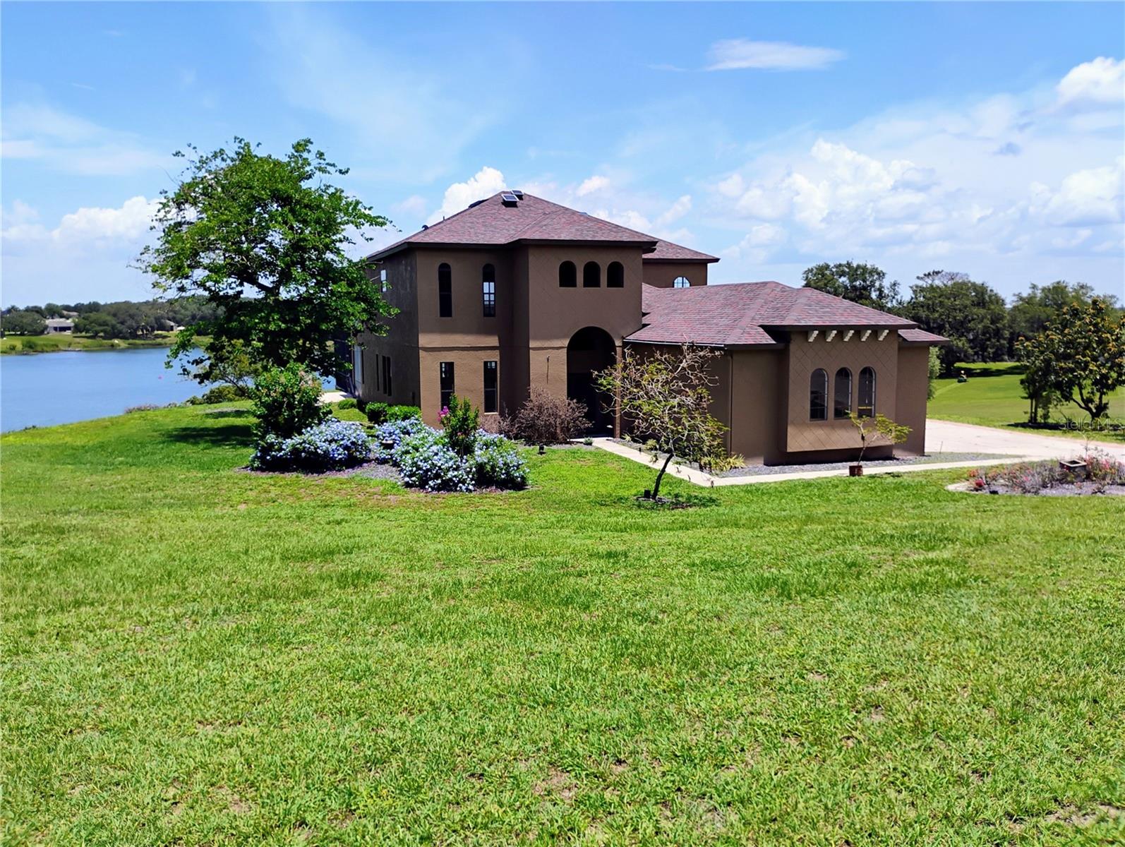 Discover the perfect blend of elegance and comfort in this 5-bedroom, 4-bathroom lakefront estate, nestled on over an acre in a golf community. This home offers an open, sun-filled layout with cathedral ceilings and hardwood floors throughout, creating an elegant yet inviting atmosphere.
The first-floor primary suite is a true retreat, featuring a spa-inspired en-suite with a Jacuzzi tub, separate shower, dual vanities, and a private water closet. It also boasts a large walk-in closet plus a secondary built-in closet for exceptional storage. A second bedroom and full bath on the main level add flexibility for guests or multi-generational living.
Designed for both daily living and entertaining. The gourmet eat-in kitchen is a chef’s dream, featuring a large kitchen island, a spacious walk-in pantry, and a wine closet, offering both style and functionality. The inside laundry room adds convenience to daily living.
Upstairs, you'll find three additional bedrooms, including a Jack and Jill bath, along with a large open loft—perfect as a media room, game room, or additional living space. The bonus room is a standout feature, complete with custom built-in bookshelves, making it the perfect home office, library, or creative retreat.
Enjoy the best of Florida living with a screened-in saltwater pool and an expansive patio overlooking the peaceful lake. An upstairs balcony offers an additional spot to unwind and take in the serene water views.
With a new roof (2020), new AC (2020), and low HOA fees, Solar Water Heater, this home offers both style and peace of mind. Experience the best of lakefront and golf course living—schedule your private showing today!