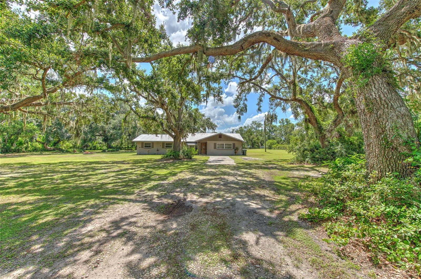 One or more photo(s) has been virtually staged. ***MOTIVATED SELLER! ANY AND ALL OFFERS WILL BE CONSIDERED *** Seller is very easy to work with and will assist with buyers closing costs.*** Ample room to convert to a 4-bedroom/3-bath. This 3-bedroom, 2-bathroom home offers so much. This gorgeous 2 acres +- has No HOA, no CDD, and no community deed restrictions. Bring your toys, RVs, work trucks, trailers, or just about anything else you could want. This home is surrounded by majestic, meandering oak trees adorned with lush bromeliads and staghorn ferns. The expansive, beautifully manicured yard offers generous outdoor space, perfect for relaxing, entertaining, or enjoying nature. Inside, the home features a spacious and thoughtfully designed layout, ideal for both quiet living and hosting guests. This home has been updated and has a nearly new 50-year metal roof, ensuring lasting durability and curb appeal. Additionally, the property provides room to expand the home, offering flexibility for future plans. This must-see gem is a rare opportunity you won’t want to miss—a slice of Central Florida paradise that blends practicality with charm. This is a must-see! NOTE: The largest bedroom has an open doorway and can be closed in for the buyer’s convenience. Buyer or buyers agent to verify all pertinent information.
