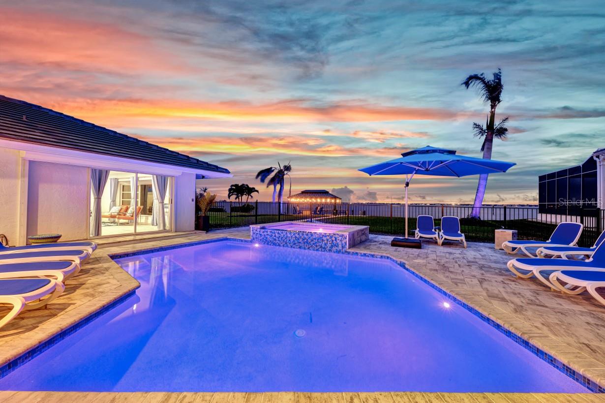 Gorgeous RIVERFRONT POOL home with EXPANSIVE views of the Caloosahatchee. This 7 bedroom, 4 bathroom home was completely remodeled in 2021. The open kitchen features QUARTZ waterfall counters, SS appliances, soft-close cabinets and drawers and a massive L-shaped breakfast bar and work surface. There is a large pantry and wine room adjacent to the kitchen. This spacious 2 story home boasts over 3800 sf of living space that can accommodate family gatherings and is currently being used as a vacation rental. The first floor Owner’s Suite has access to the lanai, and features a wet room with double shower heads, soaking tub and dual sinks, plus a MASSIVE custom walk-in closet. Upstairs you will find 3 more bedrooms, a bathroom and 2 large family rooms with access to a large balcony to enjoy the Florida sun. The updated heated pool and spa is surrounded by a large pavered lanai perfect for sunbathing and enjoying the breathtaking river views. Other 2021 upgrades include a tile roof, A/C, new gutters and more! Located in the highly sought after Palaco Grande neighborhood, this property has an extra deep lot of 195' and 80' of river frontage.