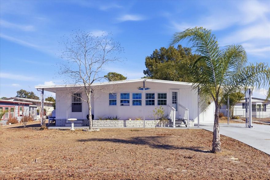 Located in the gated 55+ Brookridge golf community with a 24-hour guard, this well-maintained home offers land ownership with no lot rent and low HOA fees. The open floor plan features 2 bedrooms and 2 full bathrooms, a bright living and dining area filled with natural light, and a generously sized kitchen with abundant cabinetry and an updated backsplash. Recent improvements include a TPO roof and vapor barrier installed in 2019, a newer electrical panel (2024), an updated hall bathroom (2024) with a deep tub and updated backsplash, new flooring, a newer washer and dryer, and a freshly painted exterior in 2025. An enclosed sunroom adds approximately 140 square feet, bringing the total usable living space to 1,060 square feet, along with additional storage in the washer and dryer room. A double driveway provides convenient guest parking, and residents enjoy access to golf along with a variety of community amenities including tennis, shuffleboard, and a heated pool.