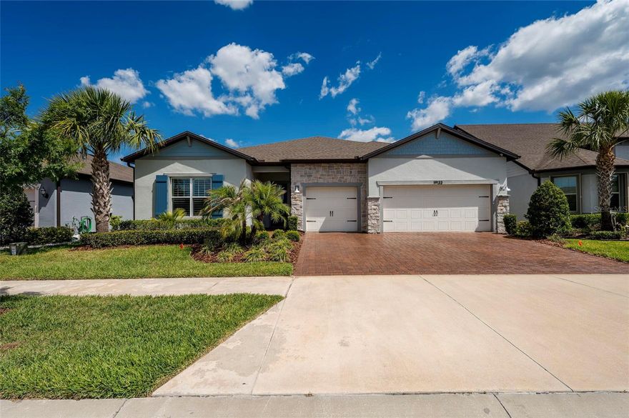 Discover this charming home in Bexley, Land O Lakes, FL featuring an inviting open floor plan with ample natural light. It is the largest single-story floor plan in Del Webb Bexley (3 BR 3 ½ BA) with an expanded gathering room! This "Renown" model spans nearly 3,000 SF with over $230k in masterfully curated upgrades. The architectural elegance begins with a sealed cobblestone driveway that shimmers with a deep luster. A warming charm of a Nappanee stone veneer facade, and a classic functional Colonial Blue storm shutters add timeless curb appeal and a welcoming, traditional aesthetic to the home's exterior. Inside, the soaring 11 ft ceilings and Shaw Alabaster Luxury Vinyl Planks suggest a refined, creamy oak visual, bringing an airy, luminous aesthetic to this modern space. You will be directed to the expanded Great Room featuring a 12ft tray ceiling and a full height 11ft Quartz stone feature wall with a built-in multimedia LED fireplace and a dedicated area for a large screen TV. This gem of a home is powered by Synergy Florida’s Control4 advance ecosystem with theater-grade surround sound and motorized shades. A chef’s dream kitchen boasts a 10ft Silestone Quartz island, built in KitchenAid double-oven suite, microwave, and full-height Carrara polished large herringbone backsplash, plus an upscale home bar with wine fridge. The Owner’s Suite presents a serene retreat featuring plantation shutters and TWO walk-in closets, including a custom dressing room and a secondary tech-hub closet. The master bath provides a zero-entry seamless glass shower. Two additional ensuite bedrooms (one features an accessible CleanCut convertible tub/shower + dual safety grab bars) both with walk-in closets. A versatile flex room with CAT6 ports provide ample space. Step through triple sliders to a 600 SF screened lanai with Ivory Shellock "cool-touch" pavers, a 6-person spa, and conservation views. 3-car garage with epoxy floors, Gladiator racks, and a whole house NuvoH2O water treatment system. Hurricane-ready with accordion shutters and motorized screens. Enjoy resort amenities: 19k SF clubhouse, heated pools, pickleball, and a full-time lifestyle director. Relax and enjoy your new care-free lifestyle. Welcome home!