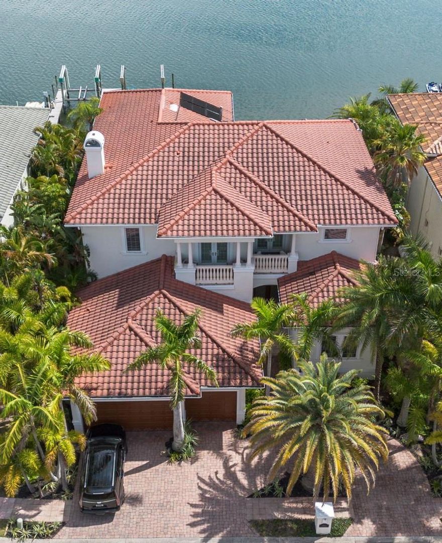 Welcome to your dream waterfront oasis, custom built by the renowned Alvarez Homes in 2002. Nestled within an exclusive gated enclave of just 28 private residences, this stunning residence offers a harmonious blend of luxury, comfort, and unparalleled style, making every moment here an experience in serene living. As you enter the grandiose doors, be greeted by stunning open water views, soaring 12-foot ceilings and a striking staircase that set the stage for the exquisite details to follow. The elegant crown molding, upgraded stone, and hand-scraped walnut hardwood floors guide you through spacious, sunlit rooms, each telling its own story of luxury and sophistication. The home's layout includes five generous bedrooms, each with its own unique charm, accompanied by 5.5 baths, a dedicated office space, a cozy loft, and a versatile bonus room, all designed to cater to your every need. The heart of this home lies in its breathtaking kitchen, recently remodeled to feature stunning quartzite countertops and backsplash, state-of-the-art GE Monogram appliances, and a custom coffee room complete with a wet bar, ensuring that your culinary experiences are nothing short of extraordinary. The adjoining walk-in pantry further complements your storage needs. The owner’s retreat is a sanctuary of peace and luxury, boasting a private balcony with awe-inspiring views of Tampa Bay, a remodeled bathroom featuring a walk-in shower, a relaxing Jacuzzi tub, and an extensive custom walk-in closet. The added convenience of a morning bar, equipped with a refrigerator and microwave, ensures that comfort is never more than a few steps away. Step outside to discover an outdoor paradise designed for the ultimate Floridian lifestyle. The solar-heated pool, accented with a tropical stone waterfall, invites you to bask in the sun, while the extended Trex deck and spacious covered lanai provide the perfect backdrop for entertaining or tranquil relaxation. The spacious covered patio, outdoor kitchen, wet bar, and pergola invite al fresco dining and gatherings waterfront and under the stars. The meticulously xeriscaped gardens, enhanced with professional outdoor lighting, pave the way to your private dock, equipped with a motorized boat lift, promising endless adventures on Tampa Bay. Additional amenities include dual laundry rooms, two gas fireplaces for cozy evenings, plantation shutters, and Pella doors for an added touch of elegance. The property is also equipped with a whole-home water softener, two Trane HVAC systems, two reverse osmosis systems, and a tankless water heater, ensuring that every aspect of your home is as comfortable as it is luxurious. Embrace the opportunity to live in one of Tampa Bay’s most coveted addresses. With its oversized three-car garage and circular driveway, this home is a testament to refined living, where every detail is a reflection of uncompromising quality. Central location provides quick and easy access to shopping, dining, entertainment, Tampa International Airport, Downtown and an easy commute to top rated Gulf beaches. Schedule your showing today!