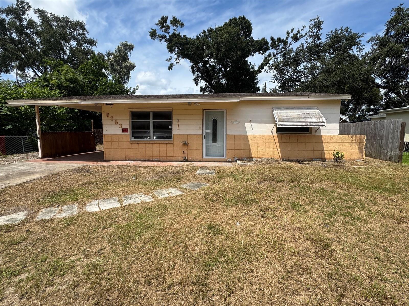 Auction Property. Outstanding opportunity for rental investors and repair and re-sell investors. The home sits on a lot that is next to a small canal used for rainwater run off. This canal provides a little extra privacy on the west side of the lot. The lot is very spacious with a large backyard. There is room for a pool or an addition. Inside there is no wasted space. Two bedrooms and one bath are in the front of the home. The primary bedroom and primary bath are in the back of the home. In between is a living room, kitchen and a family room. There is room in the kitchen for a small bistro table and chairs. At the back of the carport is a utility room. The home is being sold AS IS. It needs work, but at this price it is a real value.