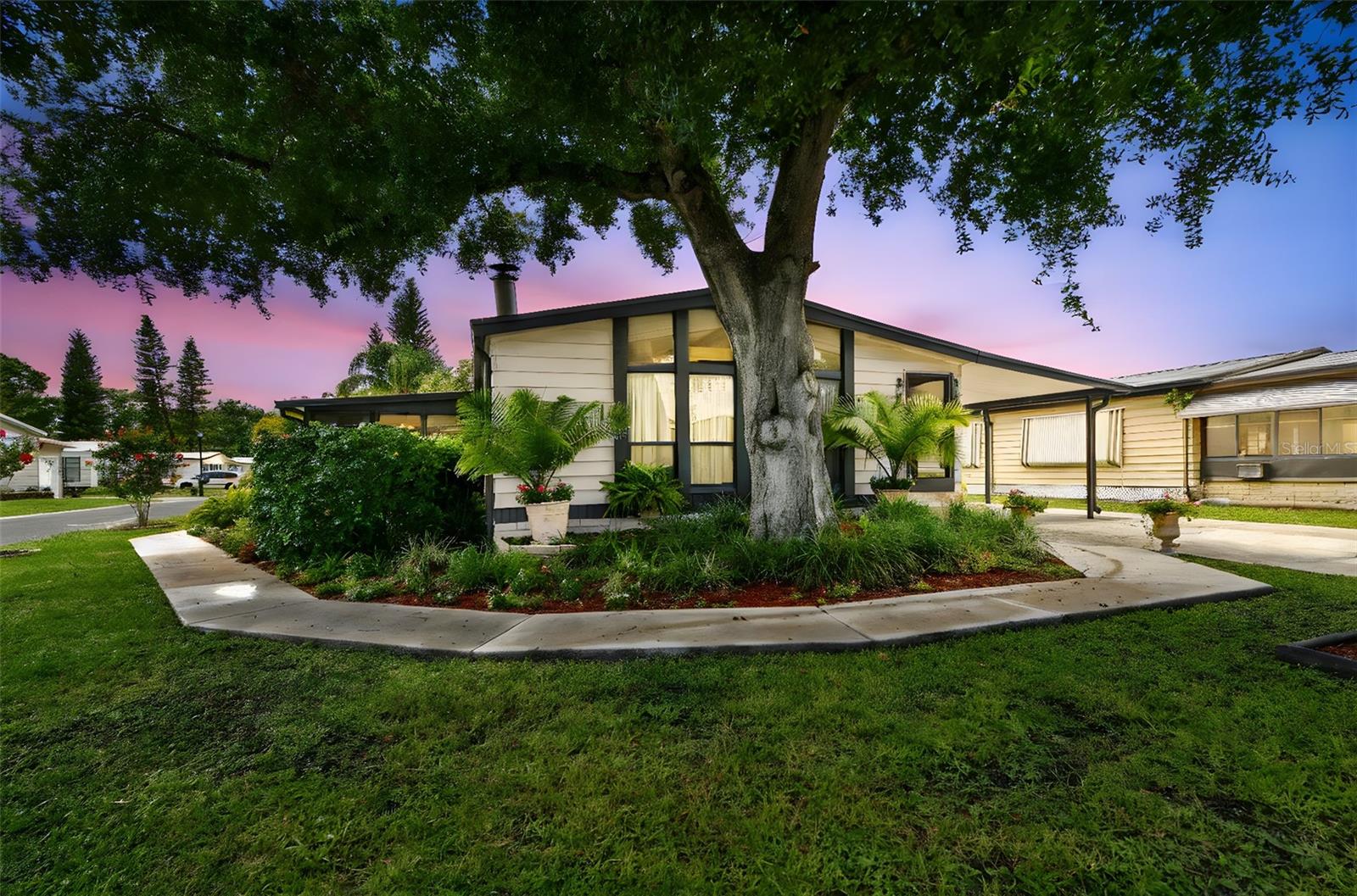 WELCOME TO SHELDON WEST MH COMMUNITY! This is a beautifully maintained 55+ community is in Tampa Florida. The homes are fee simple in this community so you own the land your home is on. No lot fees!. The community is not in a flood zone and had no damage from the recent hurricanes and has low HOA fees. Wonderful neighbors and close to medical facilities and shopping . This is an extra spacious 2 bedroom 2 bath home beautifully landscaped corner lot with a 20 x 10 enclosed Florida room, over 1500 sq ft of living area. Spacious living room and dinning room with built in storage and a wood burning fireplace with a large mantel. The tall ceilings give an open and airy feeling. The kitchen has a island combination breakfast bar and new stainless appliances . There is a wet bar for entertaining and a laundry room is inside the home. Large Master bedroom is in the back of the house with walk in closet and large bathroom with a tub and shower. The second bedroom has is a full bath that you can be entered through the bedroom or the hall. There is a large dinning area for formal dinning and a breakfast area both are off the kitchen. Tons of cabinets, storage and built in's through out the home. The Florida room is sunny and bright and has windows and a door leading to a beautiful outside garden and patio with a pergola. This outside patio is perfect for sitting and enjoying the Florida weather. On the north side of the home is a huge storage or work room with a large safe that is permanently attached, 2nd refrigerator/freezer and a Culligian Water System - They all stay! The carport and drive are cement and can park 2 cars under cover and 3 more in this large drive way. There is a great Community Club House with a large pool . Lots of activities to stay busy here! This gem has been dearly loved and cared for! Make this little piece of heaven your home. Call for a showing today.