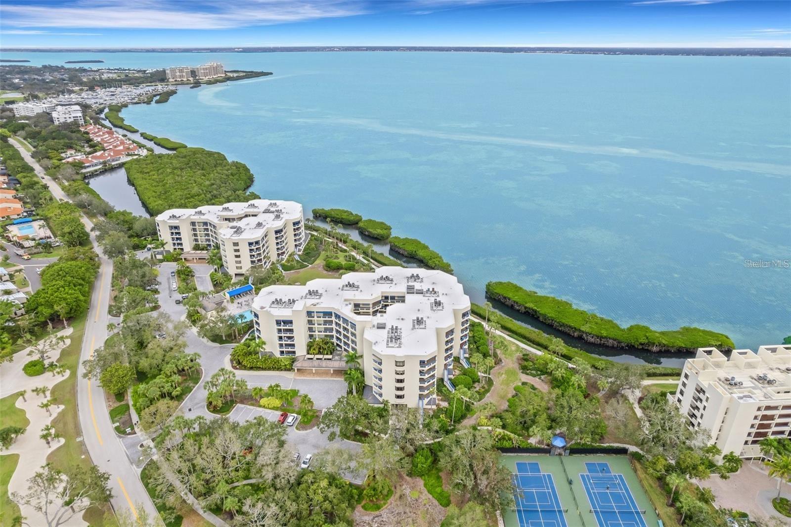 Carefree living awaits you with beautiful panoramic views of Sarasota Bay in this beautiful condominium at The Atrium on Longboat Key inside Bay Isles. This spacious updated unit is move-in ready for you to enjoy all that Florida living has to offer! The large kitchen is open to the dining/living rooms that overlook the gorgeous Bay. You can enjoy beautiful sunrises or evening gatherings from inside your unit or on your spacious private balcony. There are 2 bedrooms plus a den that's being used as a bedroom (closet can easily be added). Set "behind the gates" of Bay Isles, the Atrium offers residents a laidback, amenity-rich way of life featuring 24 hour gated security, under building-parking, a spacious storage room, walking pathways, kayak launch, heated community pool, fitness center/exercise room, tennis/pickleball courts, recently updated clubhouse, community BBQs, even added new 2EV charging stations. An extra bonus with this condo is you will receive a highly sought after beach access membership to the Bay Isles Beach Club which is across the street. To get to the beach there is even an underground tunnel for easy access so no waiting to cross the road. Newer AC (2018). This beach club provides a stress-free beach life with easy parking, storage lockers for beach chairs, ice machine, refrigerator as well as recently updated spa-like bathrooms making it convenient for residents to sit back, relax and enjoy beach life. Longboat Key Golf & Tennis Country Club memberships and deep water slips are available. Only a short distance to Publix with easy quick access that's walkable from the back road of Bay Isles. The Atrium with only 40 units has a charming quaint peaceful feel throughout.