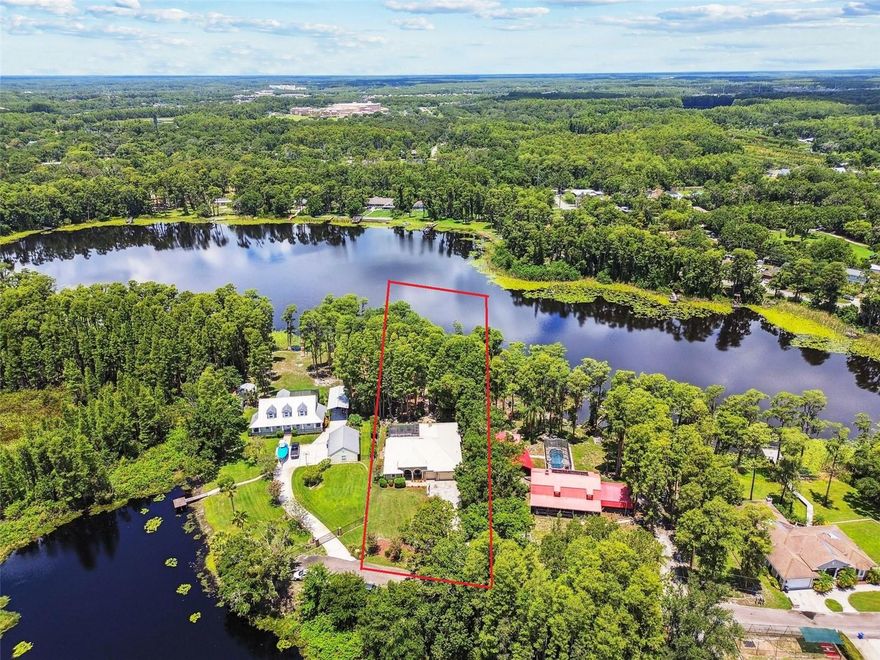 Tucked away on a peaceful dead-end street in the heart of Lutz, this stunning lakefront home offers the perfect balance of privacy, space, and natural beauty. Situated on an expansive 0.67-acre lot with stunning views of South Crystal Lake, this beautifully designed home features 3 bedrooms, 3 full bathrooms, a spacious office that can serve as a fourth bedroom, and a 3-car garage. With picturesque water views, this home invites you to enjoy an outdoor lifestyle like no other. Spend your mornings paddle boarding or kayaking from your private dock, and your evenings taking in a breathtaking westerly sunset. The quaint front porch and double glass entry doors welcome you inside. The warm, elegant interior is filled with upscale details including 12ft ceilings, plank wood flooring, crown molding, tray windows, plantation shutters, and thoughtfully designed architectural niches. The open-concept layout places the kitchen at the heart of the home, where you’ll find granite countertops, all-wood cabinetry, a large island with breakfast bar, and a stone backsplash. The eat-in dining nook, with its charming corner window, offers open views of the pool area. Formal living and dining rooms provide ideal spaces for entertaining, while the sun-lit living room features 8-foot sliding glass doors, tray windows, and a cozy gas firepl ce. The split-bedroom layout gives the master suite its own private wing, complete with pool access, tray ceilings, two walk-in closets, and a spa-like bathroom with dual vanities and a seamless step-down tile and glass shower. Step outside into the highlight of the home—a full screened-in pool area with a heated pool, spill-over spa, and stamped concrete patio, all designed for year-round enjoyment and views of the lake. Additional upgrades include automated sun shades, a whole-home propane powered generator for peace of mind, and a durable metal roof built to last. This rare lakefront gem offers peaceful seclusion with the freedom of no HOA or CDD, all while being just minutes from the conveniences of the city. Don’t miss the chance to make this exceptional property your forever home.