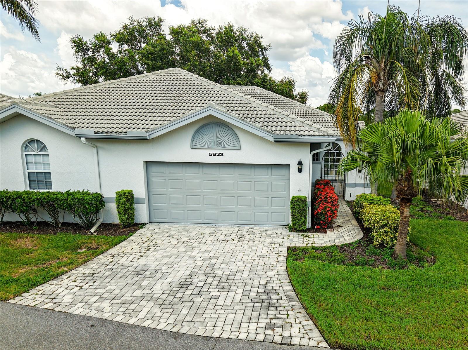 Virtual tour link in MLS is actual 3D tour, not a slideshow - please visit it! Furniture is optional with listing.
Welcome to this beautifully maintained 2-bedroom, 2-bath villa located in the highly desirable Long Common enclave within The Meadows. This single-story home offers 1,264 square feet of bright, open living space, ideal for those seeking a low-maintenance Florida lifestyle. Step inside through a charming courtyard entry with a brick-paver driveway and a 2-car garage. Inside, the great room impresses with high ceilings, crown molding, and direct access to a Florida room that features a panoramic view of the pond and fairway in the distance—perfect for relaxing or entertaining year-round.
The kitchen features stainless appliances, stone countertops, a cozy bay-window breakfast nook, and a convenient pass-through to the living and dining areas. A split-bedroom floor plan ensures privacy, with the primary suite offering a walk-in closet, dual sinks, and a walk-in shower.
Residents of The Meadows enjoy access to three golf courses, tennis and pickleball courts, a Jr. Olympic-sized heated pool, clubhouse, fitness center, and miles of scenic walking and biking trails. The community is also ideally located near Nathan Benderson Park, the upcoming Mote Marine Aquarium, University Town Center Mall, and a wide variety of shopping, dining, and cultural attractions in downtown Sarasota.