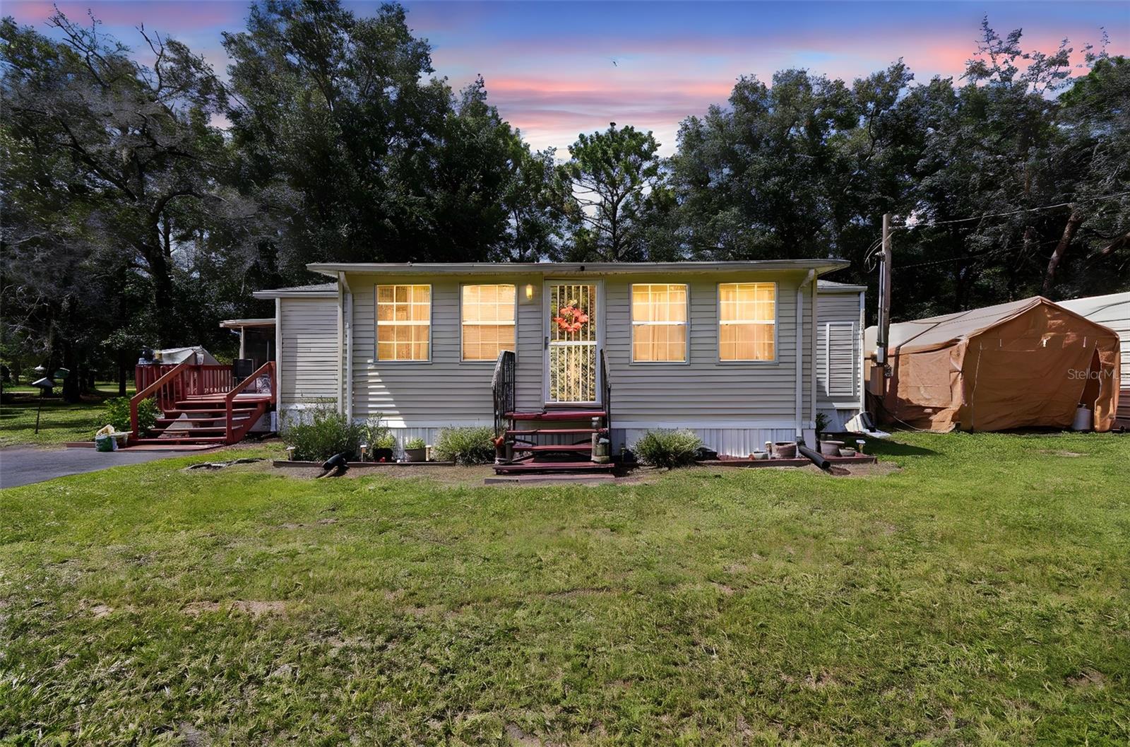 Discover the perfect combination of space, style, and smart upgrades in this move-in-ready 3-Bedroom, 2-Bath manufactured home — complete with your own land and over an acre of fully fenced privacy. Whether you’re looking for room to roam, space for hobbies, or a property that’s ready for RV living, this home delivers it all.
Step inside and enjoy the warm feel of new laminate flooring throughout, two beautifully updated bathrooms, and a thoughtfully designed split floor plan offering comfort and privacy for all. The kitchen shines with brand-new appliances — including a dishwasher, refrigerator, and oven cooktop — all supported by a new water heater and new water softener, adding both value and convenience.
Outside, the benefits keep coming: a screened porch with deck invites you to enjoy quiet mornings or evening gatherings, while the RV carport keeps your travel-ready lifestyle easy and protected. Multiple sheds provide abundant storage, and the property’s infrastructure is well cared for with a 4-year-old leach field and 1,000-gallon septic tank — offering peace of mind for years to come.
This property is a rare find in today’s market — combining modern updates, functional amenities, and outdoor freedom without the restrictions of HOA living. With plenty of space for gardening, pets, play, or even future projects, this home is perfect for those who want to live comfortably and independently.