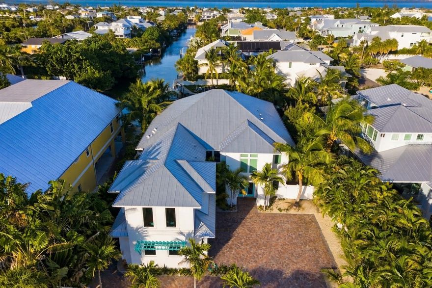 An exceptional opportunity to experience true island living where waterfront boating and beach access come together—just minutes apart—on Anna Maria Island.

This beautifully designed 4-bedroom, 4.5-bath turnkey furnished coastal residence offers a rare blend of luxury, comfort, and lifestyle, ideally situated on a tranquil canal while remaining only moments from the island’s world-famous white-sand beaches.



Homes offering private boating access this close to the beach are increasingly difficult to find on Anna Maria Island. From this property, enjoy the freedom of launching your boat from your own backyard, paddleboarding at sunrise, or cruising to open water—then return home and head to the beach cart in minutes. It is this seamless balance of water, sand, and island convenience that truly sets this home apart.



Built in 2020 and thoughtfully designed for modern coastal living, the home features a bright, open floor plan filled with natural light and enhanced by coastal-inspired finishes and refined details throughout. The gourmet kitchen serves as the heart of the home, equipped with top-of-the-line stainless steel appliances, quartz countertops, a wine refrigerator, and generous prep and storage space—perfect for entertaining after a day on the water or hosting family and friends.



Each of the four bedrooms includes a private en-suite bath, offering comfort and privacy for owners and guests alike. An elevator provides easy access to all levels, adding convenience for everyday living.



Outdoor living is where this home truly shines. The private backyard retreat features a heated pool and spa with sun exposure, an expansive pool deck, lush tropical landscaping, and multiple outdoor living and dining areas designed for relaxing, entertaining, and enjoying the island breeze. Whether you’re gathering for sunset cocktails, enjoying a quiet evening under the stars, or unwinding after a beach day, this space feels like a personal resort.



For boating enthusiasts, the property offers a private 16’ dock and an oversized boat slip measuring approximately 12’ x 35’, providing direct access to Tampa Bay and the Gulf. This setup is ideal for daily cruising, fishing excursions, paddleboarding, or simply enjoying the peaceful waterfront setting.



Situated on an unusually large lot for Anna Maria Island, the home also provides ample parking, a spacious driveway, garage, and dedicated golf cart storage—features that add meaningful convenience for both owners and guests in this sought-after location.



Located in the heart of Anna Maria Island, this property places you just minutes from pristine beaches, Pine Avenue’s charming boutiques and dining, Bean Point’s legendary sunsets, local art galleries, and the island’s laid-back, walkable, golf-cart-friendly lifestyle. Known for its relaxed pace, vibrant community, and old-Florida charm, Anna Maria Island continues to be one of Florida’s most beloved coastal destinations.



Whether you are searching for a full-time residence, a luxury second home, or a proven income-producing vacation rental with forward bookings already in place, this exceptional property offers unmatched versatility and long-term value. Combining waterfront access, beach proximity, turnkey luxury, and an unbeatable island location, this home represents a rare chance to own one of Anna Maria Island’s most desirable lifestyle properties.