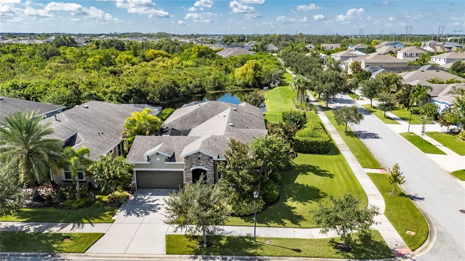 6903 Crestpoint | 3 Bedrooms | 3 Baths | Office | Lakefront | Waterset Community
Built by David Weekley, this single-story Terravista Patio Series home combines a rare private courtyard entry, screened lanai, and an oversized side yard with no rear neighbors. The lakefront setting offers peaceful views of the pond and woods, where you can enjoy shore birds, otters, and turtles from your extended screened outdoor living space.
Inside, the open floorplan connects the gourmet kitchen, dining, and family room with access to both the courtyard and lanai. Plantation shutters are installed throughout, and wide front and rear entry doors make moving and deliveries simple. The home features a tankless water heater, Nest camera, upgraded lighting, and built-in shelving in the office/media room. The kitchen includes granite counters, gas appliances, upgraded refrigerator, and a desk upgrade, while the dining room adds glass cabinetry and courtyard access through French doors.
The master suite has been extended for additional space, featuring a huge walk-in closet, towel tower between dual sinks, and a roman-style walk-in shower. Two additional bedrooms and baths are split from the master for privacy, along with a guest powder room. The screened-in courtyard, entry, and lanai allow the entire home to be opened up to the outdoors without bugs.
Outdoor features include a fully fenced yard with mature landscaping, privacy hedge, multi-zone irrigation with reclaimed water, a new electric awning with lights, LED cage lighting, spa hookup, and multiple storage options in the garage with cabinets, hanging racks, and attic storage. Commercial-grade washer, dryer, and upgraded garage refrigerator all convey.
As a resident of Waterset, you will enjoy resort-style amenities that include four heated pools, tennis and pickleball courts, basketball and volleyball courts, and two fitness centers with full gyms. The community also offers miles of walking, biking, and running trails, multiple playgrounds and dog parks, pocket parks, and open green spaces. At the heart of the neighborhood is the Landing Café, a convenient gathering spot for food, coffee, and socializing. Waterset hosts year-round activities such as concerts, food truck rallies, and holiday events, creating a vibrant lifestyle just minutes from US-41 and I-75.
