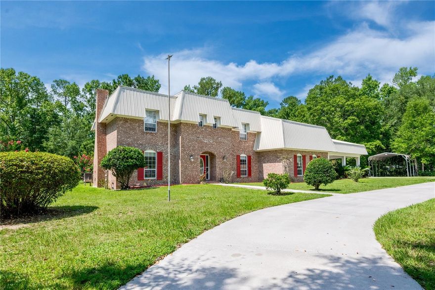 Welcome to your private oasis in Columbia County! Located in the quiet and well-established neighborhood of Westwood Acres, this stunning 4-bedroom, 3-bathroom brick home on 2 sprawling acres offers the perfect blend of elegance and entertainment. Step inside to discover a chef's dream kitchen, featuring a large island with a stovetop, ideal for lively gatherings and memorable meals. The living room serves as a central hub and thoughtfully includes the elevator, providing seamless access to the luxurious second-floor primary suite.
Outside, the resort-like amenities continue with a recently renovated inground pool for endless summer fun, complemented by a pool house that's perfect for entertaining guests poolside. Cast a line from your private fishing pond with a dock, or simply relax amidst the beautiful mature landscaping that frames this magnificent property. A two-car carport, a stately circle drive, and a large workshop for hobbies and storage complete this exceptional offering. This home isn't just a residence; it's a lifestyle!