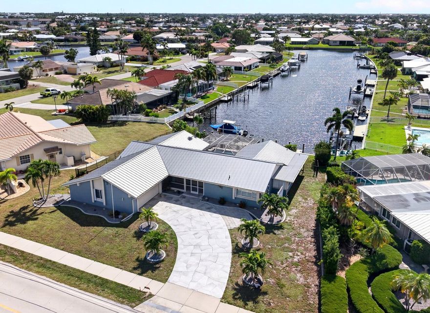 Punta Gorda Isles Waterfront Pool Home with Gulf Access! Located in a highly sought-after boating and golf community, this updated 3-bedroom plus bonus room, 2-bath waterfront pool home offers exceptional powerboat access to Charlotte Harbor leading to the Gulf. Designed for the avid boater, the property features 82 feet of water frontage with a city-maintained seawall. The extended waterfront setup includes a 60-foot concrete dock equipped with water and electric service, alongside a 10,000 lb. boat lift. Inside and out, this home exudes character and personality. The interior is defined by volume ceilings, plantation shutters, and easy-care tile flooring throughout. Large sliding glass doors in the main living area frame long water views and provide seamless access to the outdoor living space. The comprehensively remodeled kitchen is equipped with soft-close cabinetry, granite countertops, an expansive breakfast bar, stainless steel appliances, a stone-tiled backsplash, and a convenient pass-through window to the lanai. A sliding barn door leads to a versatile bonus room featuring a private entry, located adjacent to a large indoor laundry room with ample storage space. This floorplan offers two distinct primary suites, both featuring updated bathrooms with new tile flooring. Primary Suite featuring direct sliding door access to the pool area and an en-suite bathroom with dual sinks and a walk-in shower plus the Junior Suite offers abundant natural light and includes a custom-tiled walk-in shower. The outdoor space is anchored by a screened, heated pool and spa with true eastern exposure to enjoy amazing sunrises. The pool has been resurfaced and is easily maintained via a Pentair automatic pool system. A covered lanai with vaulted ceilings provides substantial shaded space for outdoor entertaining. Don't miss this opportunity to make this charming home your new Florida retreat or permanent residence!
Notable upgrades and features include new metal roof (2023), new A/C system (2021), new dock and boat lift (2020), upgraded black metal fence (2025), accordion hurricane shutters, R.O. water filtration in kitchen, security cameras, extra-deep 2-car garage with epoxy flooring, stamped concrete driveway, and mature tropical landscaping add to the beautiful curb appeal. Positioned in a premier neighborhood offering quick access to St. Andrews South Golf Club, the Yacht Club, Fishermen's Village, and historic downtown Punta Gorda. This location provides immediate proximity to world-class fishing, boating, fine dining, parks, arts, and community events.