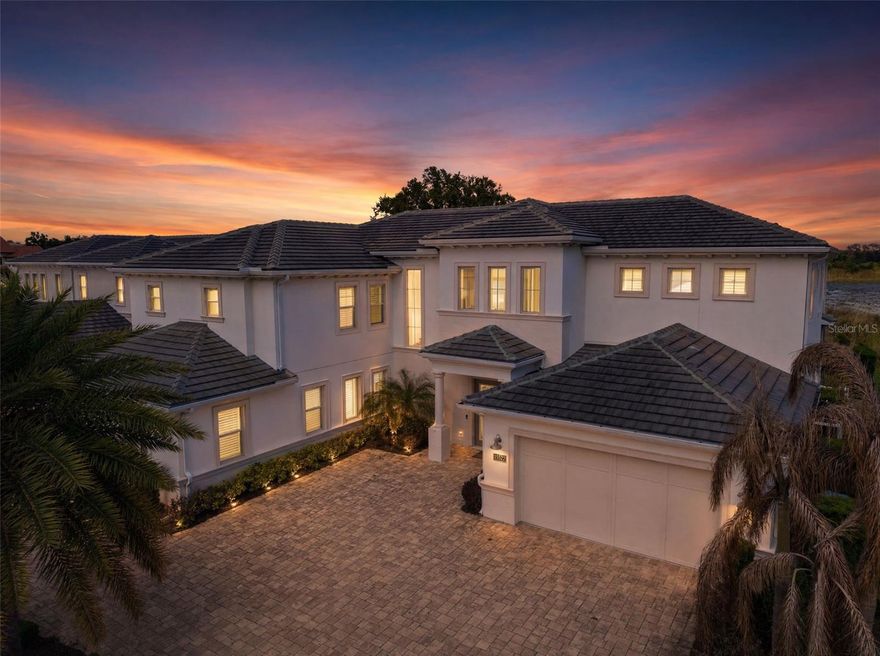 Welcome to an extraordinary estate in  Lakeshore Preserve, this exceptional lakefront estate represents a rare convergence of scale, sophistication, and resort-inspired living. Crafted by Toll Brothers, this expanded Santa Bella model stands as one of the largest and most distinguished residences in the community, offering over 6,400 square feet, 7 bedrooms, and 6.5 bathrooms. A stately tile roof crowns the home, enhancing its timeless architectural presence.

A grand sense of arrival gives way to interiors defined by volume, light, and intentional design. Formal and informal living spaces flow effortlessly, anchored by an expansive dining area and a showpiece gourmet kitchen. Outfitted with stacked cabinetry, striking quartz surfaces, a natural gas cooktop with pot filler, and an oversized walk-in pantry, the kitchen is designed to perform as beautifully as it presents.
The great room is both inviting and dramatic, centered around a natural gas fireplace and framed by expansive glass sliders that dissolve the boundary between indoors and out—revealing a private outdoor setting designed for both grand entertaining and quiet retreat.

The floor plan is curated for both elegance and flexibility. The main level hosts the primary suite along with the home’s core living spaces, creating a refined yet functional everyday experience. A private multi-generational suite offers its own living area, kitchenette, full bath, and spacious bedroom—ideal for extended family or long-term guests. A well-appointed laundry room with dual washers and gas dryers adds an additional layer of convenience.
Upstairs, the home extends its sense of scale and comfort, offering generously sized secondary bedrooms, a versatile bonus space, and a dedicated theater room—perfectly suited for elevated leisure and entertainment.
Outdoors, a true resort-style environment unfolds. The lakefront backdrop sets the stage for a custom pool with cascading waterfall, an 8-person spa, and an expansive covered lanai adorned with coffered ceilings. Lounging and dining areas invite both vibrant gatherings and serene, private moments—all framed by tranquil water views. This home also offers nightly views of Walt Disney World Resort fireworks—an iconic backdrop to your private outdoor retreat.

Residents of Lakeshore Preserve enjoy an amenity-rich lifestyle with access to a state-of-the-art clubhouse, fitness center, activity spaces, zero-entry pool, kayaking and paddleboarding, beach volleyball, playgrounds, and scenic parks. HOA includes full lawn and landscaping maintenance along with 1-gig high-speed internet.
Enjoy unmatched convenience with quick access to Walt Disney World  and Universal Studios, along with championship golf at Orange County National Golf Center and the vibrant atmosphere of Downtown Winter Garden. Families benefit from a premier school zone, including Horizon High School just across the community, Panther Lake Elementary School a short walk away, and Water Spring Middle School nearby.
With exceptional scale, thoughtful design, and a premier setting, this home stands as a true expression of luxury living and distinction.
Private showings available by appointment.
