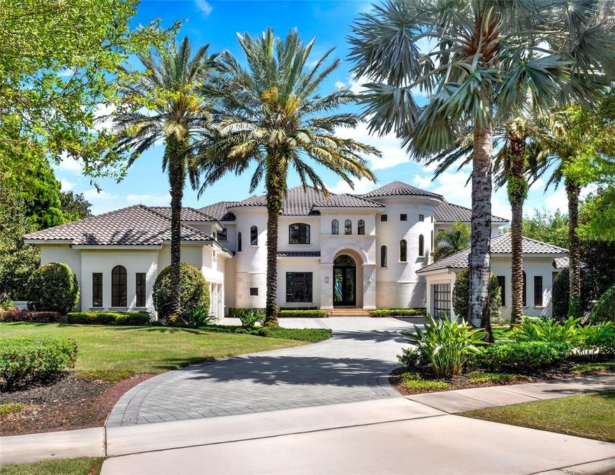 Experience luxury lakefront living on a grand scale in this custom-built Modern Mediterranean estate on Lake Tibet, part of the pristine Butler Chain of Lakes. The three-story residence spans 9,571 square feet of living space on over 2.2 acres in the guard-gated community of Keene’s Pointe in sought-after Windermere. Built by Goehring & Morgan, this architectural masterpiece offers refined craftsmanship, exquisite details and seamless indoor-outdoor living with stunning water views from almost every space. The 26-foot grand entry sets the tone for soaring handcrafted coffered ceilings, travertine marble and mahogany wood floors, custom cabinetry, designer interior and exterior finishes and an open floor plan. Inside you'll find six bedrooms, five en suite, nine baths, formal living and dining rooms, wine cellar, family room, captivating saltwater aquarium, game room, lounge/loft, two offices, a mudroom, and a home theater constructed of concrete block to also serve as a safe room. The chef’s kitchen is outfitted with Sub-Zero and Dacor appliances, Esmeralda Brazil granite countertops, LED lighting, a large walk-in pantry, a prep kitchen with additional appliances and a built-in Miele coffee station with beverage refrigerator. The owner’s retreat features a private sitting room, fireplace, wet bar, oversized custom closet, spa-like bath and a covered balcony with breathtaking lake views. A spiral staircase leads to the third floor, the highest elevation in Keene’s Pointe, where you’ll find a private study and an observation deck. Massive sliding doors open to a spectacular outdoor living space with retractable screens, tongue-and-groove ceilings, fireplace, TV and a full summer kitchen with Viking gas grill, sink and refrigerator. The resort-style saltwater pool features a Beadcrete finish, sun shelf, lazy river, slide, grotto, swim-up table and stools, island planter with palm trees, spa and dramatic water, fire and lighting effects. A putting green and built-in trampoline complete the backyard oasis. One of only two, two-story docks in Keene’s Pointe, the home's private boathouse includes two boat slips with lifts and touchless covers, plus a floating dock for jet skis. Additional features include an elevator, in-floor vacuum system, attached in-law suite with private entry plumbed for a future kitchen, two garages with room for five cars and a gated dog run. The barrel tile roof, stone entry columns, motor court with fountains and professionally designed landscaping further elevate the estate. Keene’s Pointe offers access to the Butler Chain of Lakes, a 250-acre Jack Nicklaus Signature golf course, the Golden Bear Club, resort-style pool, tennis courts, fitness center, multiple playgrounds and a clubhouse for private events. Windermere offers small-town charm with proximity to downtown Orlando, fine dining, world-class shopping, championship golf courses, top-rated schools, international and private airports, and theme parks.