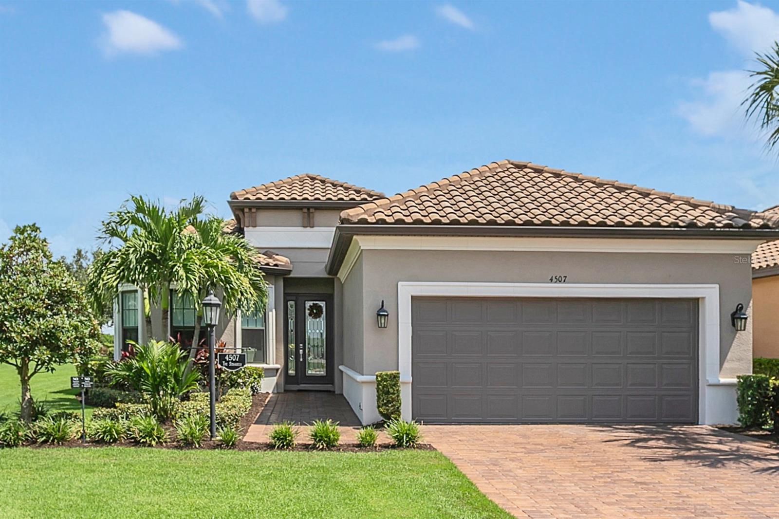 Priced to sell immediately! Entire exterior just painted! Discover luxurious comfort in this stunning, better-than-new, custom built cul-de-sac home. Located on the 12th hole of a championship golf course in the resort community of Esplanade Golf & Country Club at Lakewood Ranch. This freshly painted home includes recently sealed pavers, gutters, a new irrigation system and ground drainage system. Step inside to opulence & meticulous detail: 24” X 24” gray high gloss porcelain tile floors, 10’ ceilings, crown molding, 8’ doors, 5½” baseboard, custom-built Columns, ceiling fans & custom designer lighting throughout. The foyer boasts a tray ceiling with crystal chandelier. Adjacent to the rotunda, is a family room with a tiled accent wall, tray ceiling & large windows; the space can also function as a dining room or office. The open concept main living area features a great room with a tray ceiling, crystal chandelier, tiled accent wall and Swarovski crystal sconces. A 10’ disappearing sliding door leads to an extended covered lanai complete with outdoor kitchen, pool, fireplace and breathtaking views. The well-lit Kitchen is equipped with Samsung stainless steel appliances, double oven & 5 burner gas range, upgraded 42” light gray wood cabinets, quartz counters, glass tile backsplash, oversized island with cabinets & a custom pantry. Guest or family will enjoy 2 large bedrooms with custom built-in closets & ensuite baths. Quartz counters & custom vanity lights complete the look. The owners' retreat has a tray ceiling & a bay window. The spa-like bath has double sinks, quartz counters, custom vanity lights, a large shower & water closet with pocket door. The unique owners closet with crystal chandelier; LED lighting & glass shelves allows for beautiful organization. This home includes a half bath and full laundry room with upper & lower cabinets, drawers, utility sink, granite counter, front load washer & electric dryer. The two-car garage with 4’ extension provides extra storage space. Outside, the extended covered lanai has Remote/App controlled sun/rain screens, upgraded pavers, gas fireplace, three ceiling fans, full kitchen with granite counter & backsplash, natural gas grill, sink, refrigerator and ample cabinet & drawer space. Enjoy panoramic unobstructed views of sunrises, lake, golf course, beautifully maintained & manicured lawn & landscaping. The pool has lighted water bowls, water feature & color changing in-pool light. Residents enjoy a luxurious lifestyle with a surplus of resort style amenities. The Amenity Centers have outdoor heated pools, a resistance pool, pool tables, a card/game room, library, meeting room with full kitchen, gym with locker rooms & showers and room for fitness classes. Wellness Center has state-of the-art fitness center, locker rooms with showers, full-service spa, hair & nail salon, outdoor heated lagoon-style pool with private cabanas & poolside Bahama Bar. The Culinary Center offers fine dining & casual lunches, overlooking the 18th green, lake, & fountain. Additional amenities: walking trails, dog parks, tennis, pickleball & bocce ball courts and community events, live music & themed parties are organized by the clubs private Lifestyle Director. As a deeded golf membership home, residents have access to driving range & championship golf course, with reciprocity at other Troon Privé golf courses. HOA dues include golf, amenities, landscape maintenance and irrigation water.