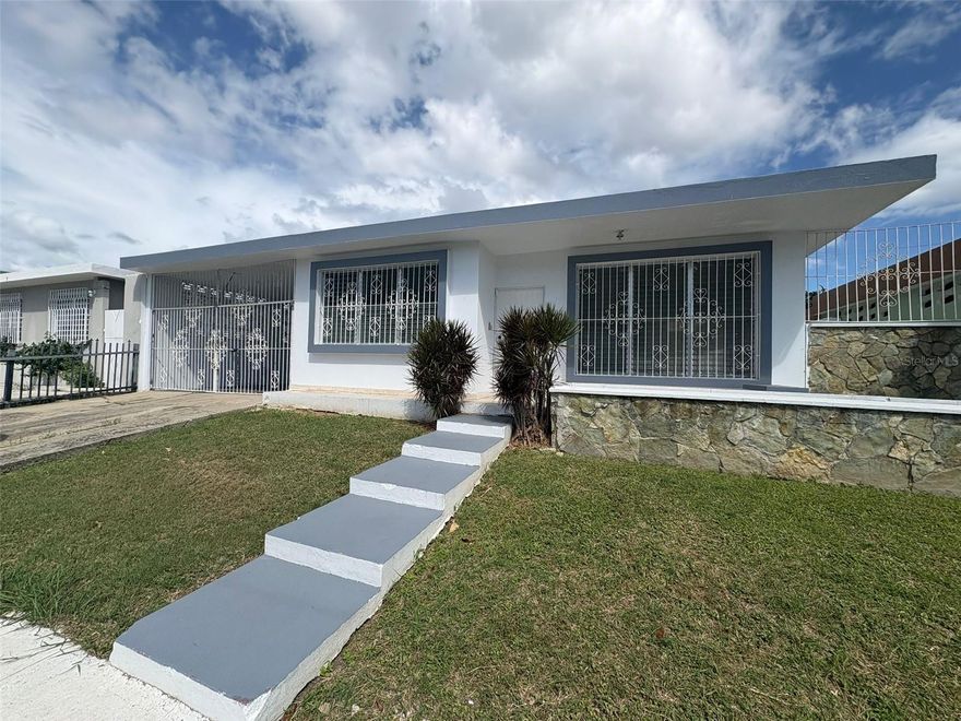 Beautiful and spacious property for sale located in La Rambla Urbanization, one of the most strategic and well-located communities in Ponce. This residence features four (4) bedrooms and two (2) bathrooms, along with a living room, dining room, kitchen, and a designated family area ideal for comfortable family living. The property includes a garage and a large fenced backyard that offers privacy and ample space for outdoor activities. Each bedroom is equipped with air conditioning, ensuring comfort throughout the home. It boasts a prime location right next to La Rambla Shopping Center on Road #14 and close to schools, with easy access to main roads. The property is ready for immediate occupancy. Schedule your showing today.