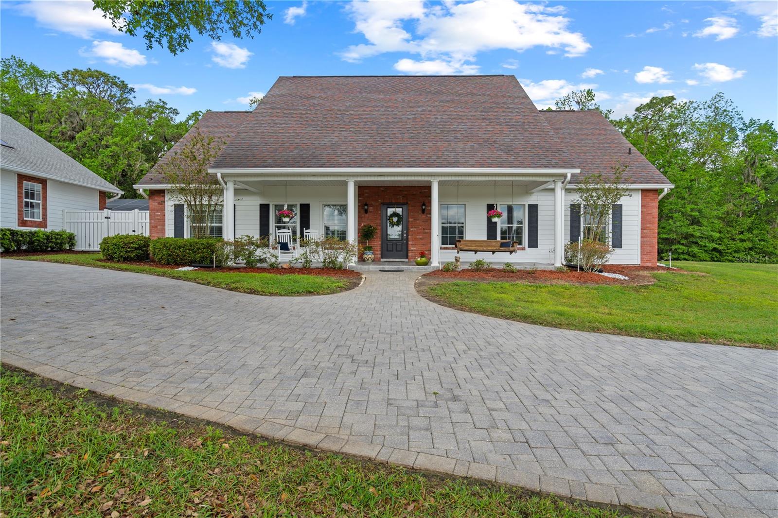 Welcome to this one of a kind, spacious country estate with old Florida charm. As you enter the property through an electronic entrance gate, you will pass by the large stock pond and gradually make your way through the private, wooded drive, which borders over 300 acres of protected Hernando County wildlife and preserved land with numerous hiking trails and natural amenities, all within minutes from this sprawling property.
Entering this impeccably maintained 3 bedroom, 2 ½ bath home, there are dramatic cathedral ceilings in Entry, Dining & Living rooms with a large flagstone fireplace and hearth. The eat in kitchen is a chef’s dream, with floor-to-ceiling custom cabinetry, bay windows and granite countertops. A spacious center island gives you additional work and eating space, with second sink and a window seat overlooking the front pasture. The oversized Primary bedroom has two large, custom walk-in closets, a walk-out, screened patio with access to the outside and attached is a natural-stone tiled bathroom with a walk-in shower, granite countertops and double sinks with separate vanities.
There is also a dedicated home office, a large family room with skylights and a separate laundry room with washer/dryer, mud sink and natural-stone tiled floor. Other upgrades include ceiling fans in all rooms and on the porch and Bimini shutters and custom draperies throughout the home.
In addition to the attached 2-car garage, other outstanding amenities include a screened porch (1540 sq. ft.), a large barn (1152 sq. ft.) and a newly renovated in-ground pool (640 sq. ft.) with sun-shelf and enclosure. There is also a detached 4-car garage connected to a finished workshop (1925 sq. ft.) - Perfect for avid hobbyists or a future large guest suite. This space includes a ½ bath and a fully-decked, standing-room attic which runs the length of the structure. High & dry location, zoned for agriculture, this all could be your perfect retreat, working farm or just about anything you could imagine!. Hurry and make an appointment to see this beautiful property before it's gone!