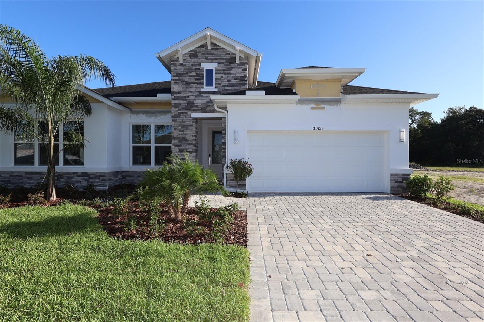 Under Construction. The Wagoner floor plan by David Weekley Homes in Wesley Chapel, is a MUST SEE! Located in desirable Chapel Crossings, a resort style community with amenities that will cause envy among friends and family. Featuring a resort style pool with lazy river, social hub, fitness center, parks, playgrounds and pickle ball courts you will enjoy the the Florida living in style! The Wagoner's vibrant natural light and limitless livability make the open-concept living spaces a designer's dream. This homes kitchen is carefully designed with white shaker style cabinetry and gorgeous Navy accented island pairs perfectly with the designer quartz. The expansive kitchen is complete with stacked cabinets to the ceiling and upgraded stainless steel appliances. Retire to the comfort of your Owner's Retreat, which features a pamper-ready en suite bathroom and a deluxe walk-in closet. The privately placed secondary bedrooms make for a beautiful flow of space among any family. Plus, it's located on a private corner home site with serene views of conservation. Being a David Weekley Home, this home comes with an industry best 1 year, 2 year and 10 year warranty. This home is ready to make yours today!