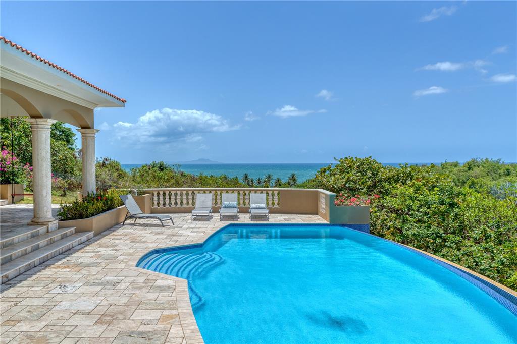 Perched high on the hills of Palmas del Mar with expansive views of the Caribbean Sea and Vieques Island. 9 Shell Castle offers the utmost privacy and seclusion, all within the confines of a gated, amenity-rich, world-class boating resort community.
Custom built in a contemporary Mediterranean style, the residence's gracious 3891 Sq. Ft. layout takes advantage of the striking ocean views throughout. Renovated in 2018, the immaculate interior is highlighted by marble floors, high ceilings, Tuscan-inspired columns and archways, as well as an open concept state-of-the-art kitchen complete with chef-grade stainless steel Thermador appliances. The main level of the home showcases multiple living spaces, dining room and laundry as well as four bedrooms and three full baths. Floor to ceiling glass sliding doors connect the interior to its lavish outdoor entertainment areas and stunning infinity pool, which serves as a gorgeous setting for watching the sunrise near Vieques every morning and gazing at the moon every night as the reflection perfectly aligns with the ocean to create a spectacular display. The lower level features a fifth ensuite bedroom in addition to ample storage areas and accommodating two-car garage.
Offering the ultimate levels of comfort and convenience, Palmas del Mar is internationally renowned for its top golf courses, tennis courts, equestrian center, private school, restaurants, shopping venues and beachfront location on the southeast coast of the island. Only a 40-minute drive away from San Juan, enjoy the pinnacle of resort living while still being in close proximity to the Metropolitan area.
Annual HOA Fee: $900.