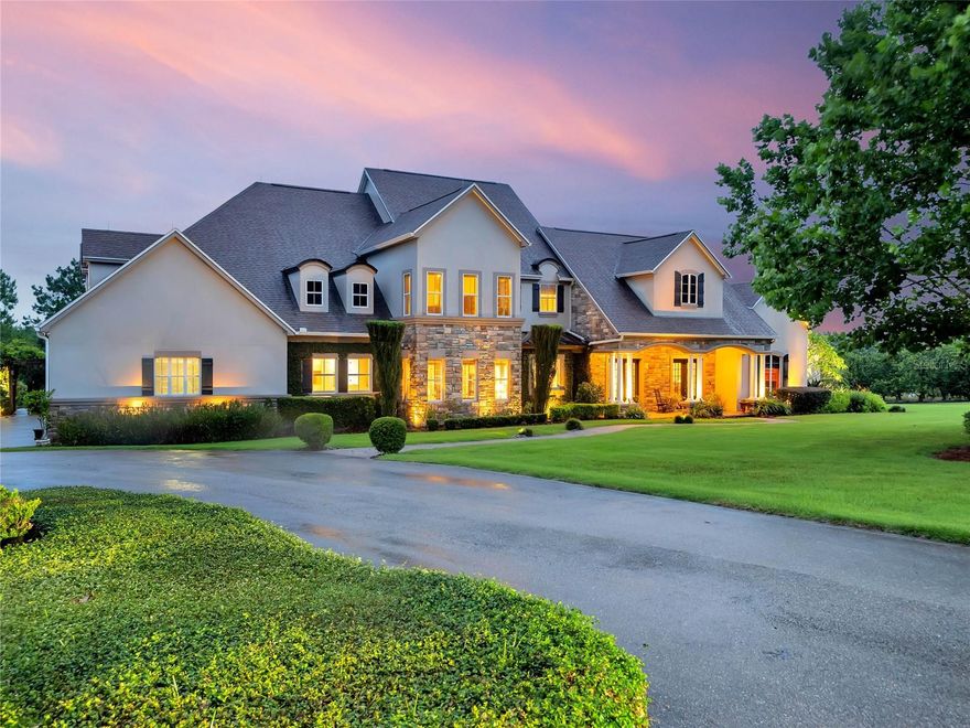 Escape the hectic world and find solace in this breathtaking 30-acre estate home located in the beautiful "Chain of Lakes City" of Winter Haven, FL, with plenty of room to build another dwelling, guest house or in-law living space. This gated and private residence is set amidst a stunning landscape that includes citrus groves, open pastures, and mature woods, making it the perfect home for families or those seeking luxurious living space with absolute privacy. The 6,800+ square feet of luxurious living space boasts 5 bedrooms and 7 bathrooms, with high-end finishes and nuances throughout. The spacious living features 21' high ceilings, a majestic travertine-accented fireplace, exquisite chandelier, and sweeping views of the surrounding acreage and pool. The kitchen is flawlessly finished with quartz and granite counters, custom cabinetry, quality appliances, and an abundance of storage and prep space, perfect for those who enjoy entertaining. The game room provides endless entertainment with room for billiards, prime seating for game day or movie night, projector with retractable screen, blackout curtains for daytime viewing, mini kitchen with refrigerator and ice maker and a half bath. The executive-level office features a soothing fireplace, coffered wood ceiling, custom bookshelves, and cabinetry to help keep things organized. The private downstairs master suite features a luxury en-suite bath with a soaking tub, walk-in shower with dual heads, towel warmer, and an oversized walk-in closet that will accommodate the largest of wardrobes. Upstairs, there are four en-suite bedrooms, each with their own bathrooms, walk-in closets, and living dimensions that guarantee relaxation. One of the guest bedrooms even includes an en-suite gym and a balcony with views of the land. Moving out of the house, your heart will literally skip a beat at the picturesque views reminiscent of the hills in Tuscany, with rolling views, planted olive trees, patio and a pool with a spa and fireplace. The land has been carefully cultivated to take advantage of current agricultural exemptions, with 9+/- acres of Hamlin oranges and 20 acres of pasture and woodlands for ATV riding, hiking, cattle, or horse grazing. Other notable features include a side-entry 4-car garage, whole house generator, sitting/keeping room, main level and upper level laundry rooms, tons of storage, security cameras, lightning protection, landscape lighting, deep well for the grove, tankless water heaters, and an unquantifiable level of privacy. Winter Haven, Florida is known for its many boating and waterski lakes, its world-famous Winter Haven Chain of Lakes, comfortable climate, and abundant natural resources and recreational opportunities. The city boasts an energetic community, a low cost of living, and a range of amenities, including world-class golf courses, beautiful parks, walking trails and a thriving downtown arts and nightlife scene. With its proximity to major attractions and easy access to stunning beaches, living in Winter Haven provides residents with a fantastic quality of life and endless opportunities for adventure and relaxation. This once-in-a-lifetime offering gives you the advantage of being less than 1 hour from Disney World, 1.5 hours to Orlando International Airport (MCO) and Tampa International (TPA) - close to shopping, dining and more. Don't wait; request a showing today and explore the endless possibilities that come with living in this Central Florida estate!