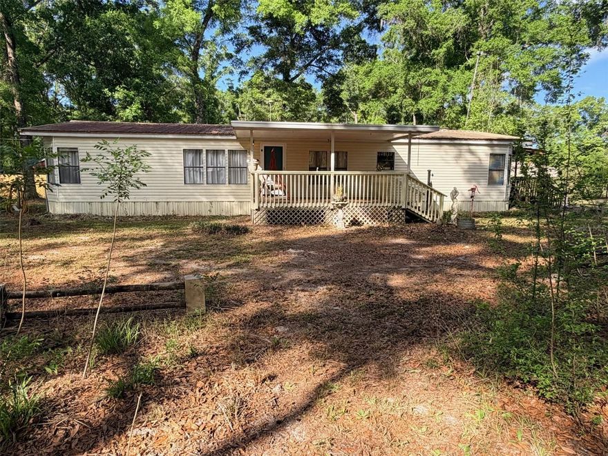 Spacious 3BR/2BA double-wide manufactured home offering 1,728 sq ft of living space on approximately 3.4 acres, ideally located between Chiefland and Fanning Springs on the east side of US-19 with paved road access. This home features a desirable split floor plan with two separate living areas, including a cozy family room with fireplace—perfect for relaxing or entertaining. The kitchen offers ample cabinet space and a bright breakfast nook for casual dining. Step outside to enjoy a nicely wooded yard that provides privacy and that “Old Florida” feel, along with multiple storage buildings offering great potential with a little TLC, pole barn and full RV hookup. Conveniently located to Chiefland and Trenton schools, shopping, and local restaurants, plus just minutes from area state parks, wildlife management areas, and the Suwannee River for boating, fishing, and outdoor recreation. Great opportunity for full-time living, rental potential, or a weekend retreat!