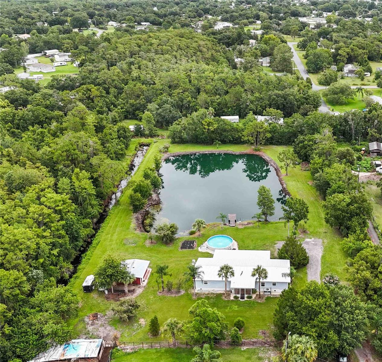 Wonderful 3 acre property located just 10 minutes from the bustling Lake Nona corridor. This gives you access to the VA and other hospitals and medical facilities with lots of shopping and many restaurants to choose from. The 3 bedroom 2 bath home has over 2,000 square feet of living space. Relaxing on the huge 46x12 back patio overlooking the pond and dock will soon become one of your favorite activities. Plenty of open space for your favorite humans to explore nature or break out the fishing poles. There is plenty of room to park your RV's, boats, ATV's and other toys. There are 2 RV hookups with 30 and 50 amp availability. The 20x20 shop is great for repairing or modifying your toys. Metal roof installed in 2020.