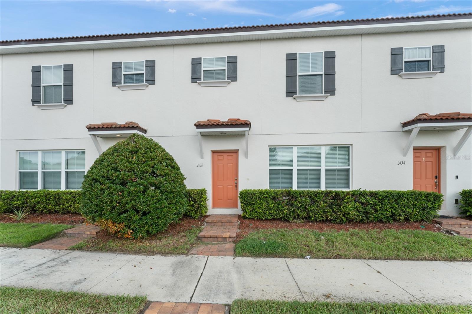 **This house comes with a REDUCED RATE through the seller's preferred lender. This is a lender-paid rate buydown that reduces the buyer's interest rate and monthly payment.**Welcome to a stylish & spacious townhome in the prime Kissimmee Location! This beautifully updated 3-bedroom, 2.5-bath townhome boasting nearly 1,600 sq ft of thoughtfully designed living space. From the moment you step inside, you're greeted by an open-concept layout, luxury finishes, and an abundance of natural light. The first floor features luxury vinyl flooring throughout and a stunning custom built-in TV unit in the living area—perfect for relaxing or entertaining. The flow continues through the dedicated dining space into a modern kitchen that’s sure to impress, complete with white shaker cabinets, stone countertops, stainless steel appliances, and an island with breakfast bar seating. A conveniently located half bath sits just off the kitchen and dining area. French doors and large windows bring in beautiful light and offer views of your private paver patio, the perfect spot to unwind or entertain. Just beyond is the detached 2-car garage with rear access for added privacy and functionality—plus, there’s additional street parking out front. Upstairs, you’ll find plush carpeting, a full guest bathroom with a tub/shower combo, and two comfortable guest bedrooms with built-in closets. The primary suite is a true retreat, featuring an eye-catching accent wall, walk-in closet, and a spa-like ensuite bath with dual sinks, sleek white cabinetry, and a floor-to-ceiling tiled walk-in shower. A dedicated laundry closet includes a stackable washer and dryer, plus a bonus cabinet and counter space for added convenience. This townhome offers low-maintenance living with the style and comfort of a modern single-family home—all in a desirable Kissimmee location close to shopping, dining, major highways, and theme parks. Don’t miss your chance to own this move-in ready gem—schedule your showing today!