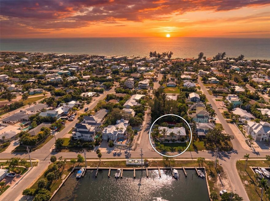 A rare find on Anna Maria Island, this elevated coastal home sits on an expansive 10,000+ square foot corner lot, offering exceptional privacy on multiple sides, an uncommon feature in the heart of Holmes Beach. Enhanced by a new metal roof (2025), newer air conditioning system (2022), storm-rated impact windows and doors, and a newly resurfaced heated pool (2025), this home offers true peace of mind and resort-style living. With weekly rental zoning, this Anna Maria Island real estate opportunity is offered fully turnkey furnished, has recently operated as a short-term rental, and is located just 3 blocks from Anna Maria Island’s sugar sand Gulf Beaches. A perfect blend of island lifestyle with strong investment flexibility. Centrally located in Holmes Beach FL, this quiet neighborhood home is close to restaurants, shopping, coffee shops, and many island attractions. This custom home is far from “cookie cutter.” Custom features include an open-concept layout with 9.5-foot ceilings, soaring tray accents, abundant natural light, luxury vinyl flooring, brand-new carpet in bedrooms, plantation shutters, and a distinctive round formal dining room that captures peaceful and picturesque views down the canal. The chef’s kitchen offers granite countertops and a spacious breakfast bar flowing into the great room, perfect for family nights or an evening of entertaining guests. The private primary suite includes an en-suite bath, a walk-in closet, and continued picturesque views of the canal. Both the primary and additional bedrooms feature built-in closet shelving and organizational systems for added ease. Step outside to a truly rare find in Holmes Beach: an oversized, completely private backyard oasis designed for ultimate relaxation. The outdoor experience begins on the elevated deck, offering the perfect vantage point over the sparkling heated pool, an ideal spot for morning coffee or evening cocktails. Below, a resort-style sunbathing terrace invites you to soak up the sun with plenty of room for intimate outdoor dining or entertaining family and friends. Fully fenced and finished with lush tropical landscaping and low-maintenance artificial turf, this expansive retreat provides the space and privacy rarely found in this area. The property offers convenient access to Sarasota-Bradenton International Airport approximately 40 minutes away, Tampa International Airport about 60-70 minutes, and IMG Academy roughly 25 minutes from the island. Plus a Holmes Beach bonus with City of Holmes Beach boat slip rentals available directly across the street on a first-come, first-served annual lease basis (currently waitlisted) for approximately $750/year.